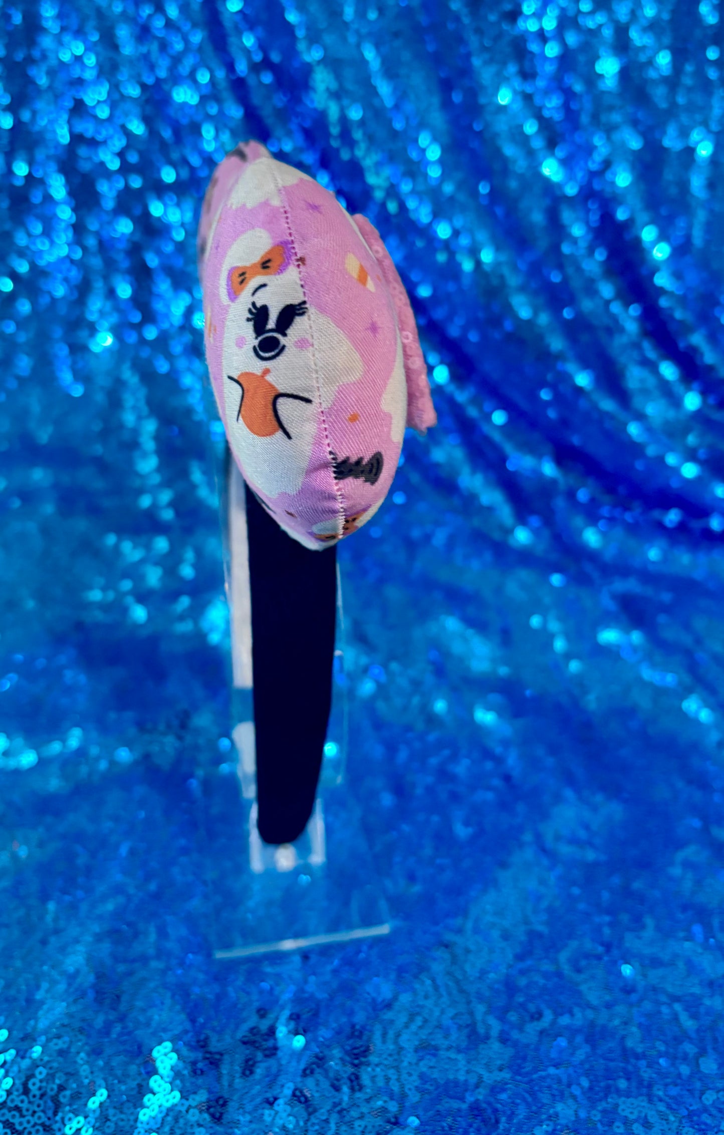 The other side view of the custom ears on a clear headband stand.