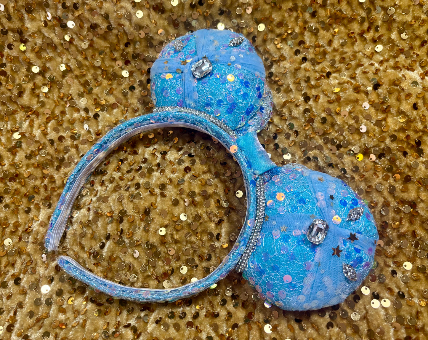 Handmade and ready to ship blue sequin mouse ears headband inspired by Cinderella with tulle and silver gemstones with a crown charm middle and rhinestone trim along inner ears. Back view of mouse ears.