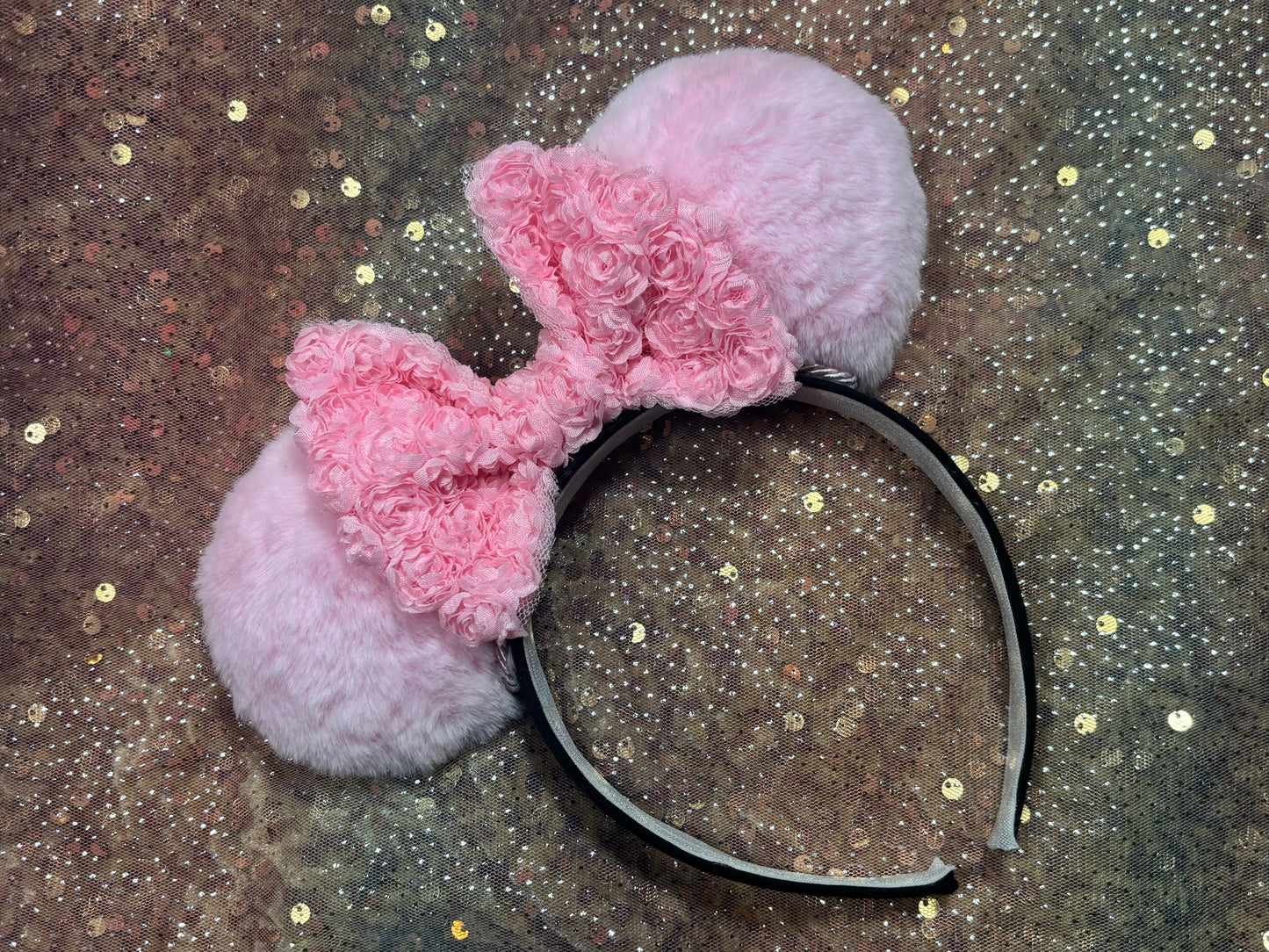 Pink fluffy mouse ears on a glittery background