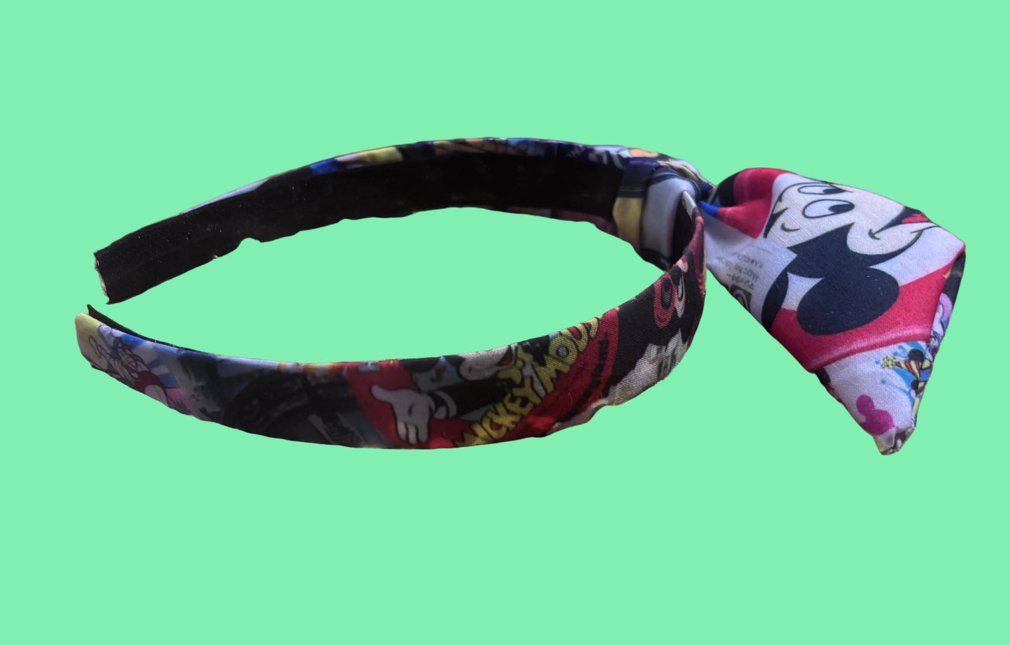 Other side of the headband with Park themed twisted headband showing views of Mickey and friends.