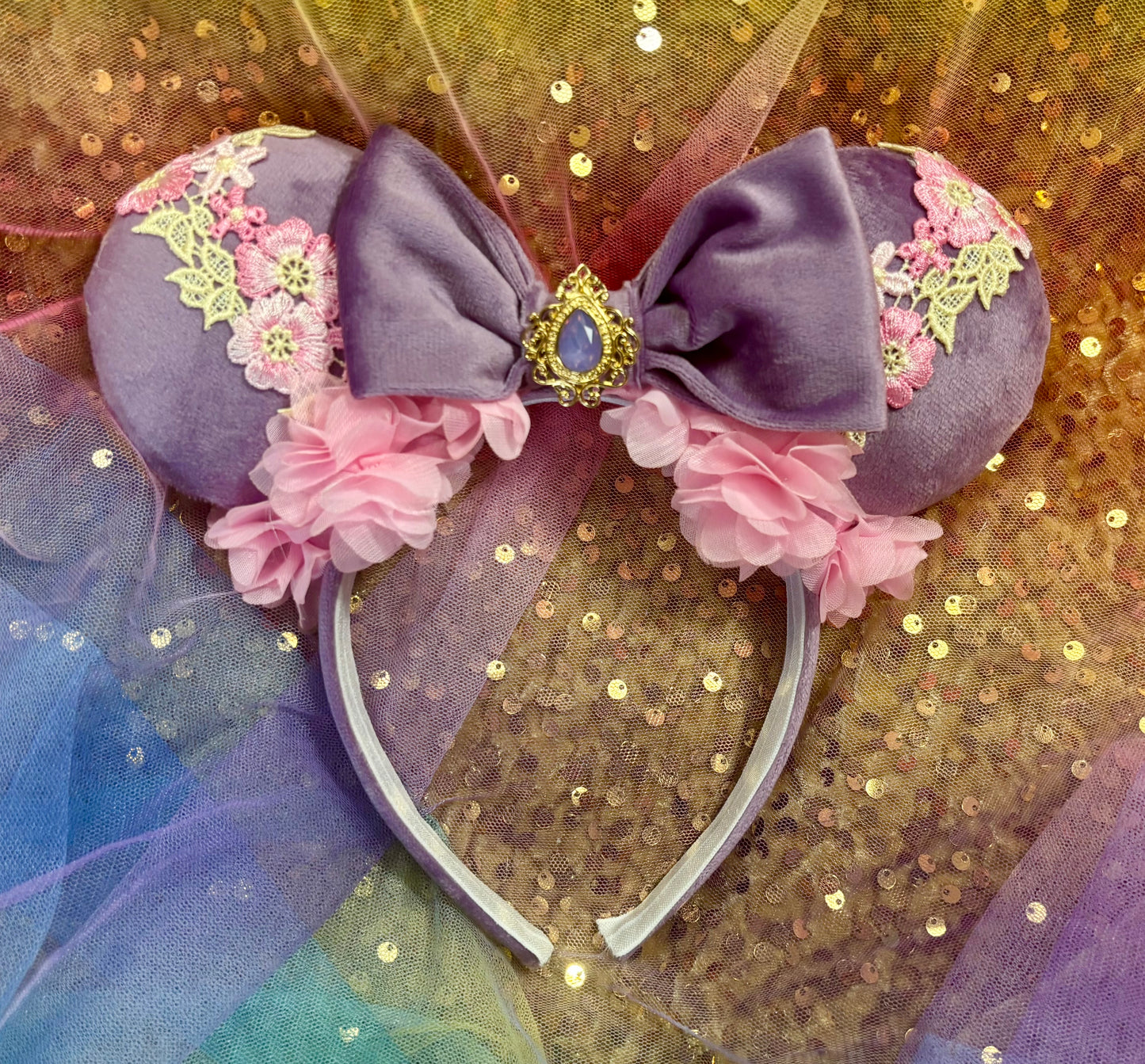 Decorative headband with flowers and a bow on a glittery background
