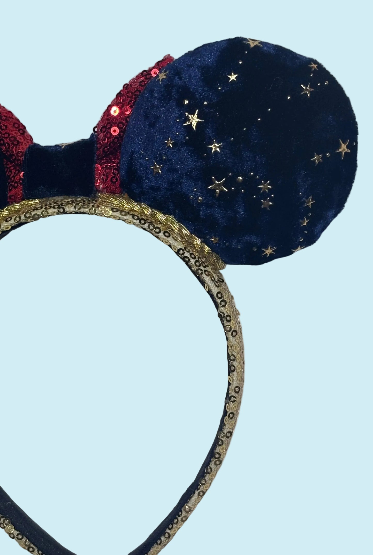 Handmade and ready to ship Navy Velvet fabric with gold stars and red sequin bow mouse ear headband on a gold sequin universal sized headband. Back right-side closer view of details.