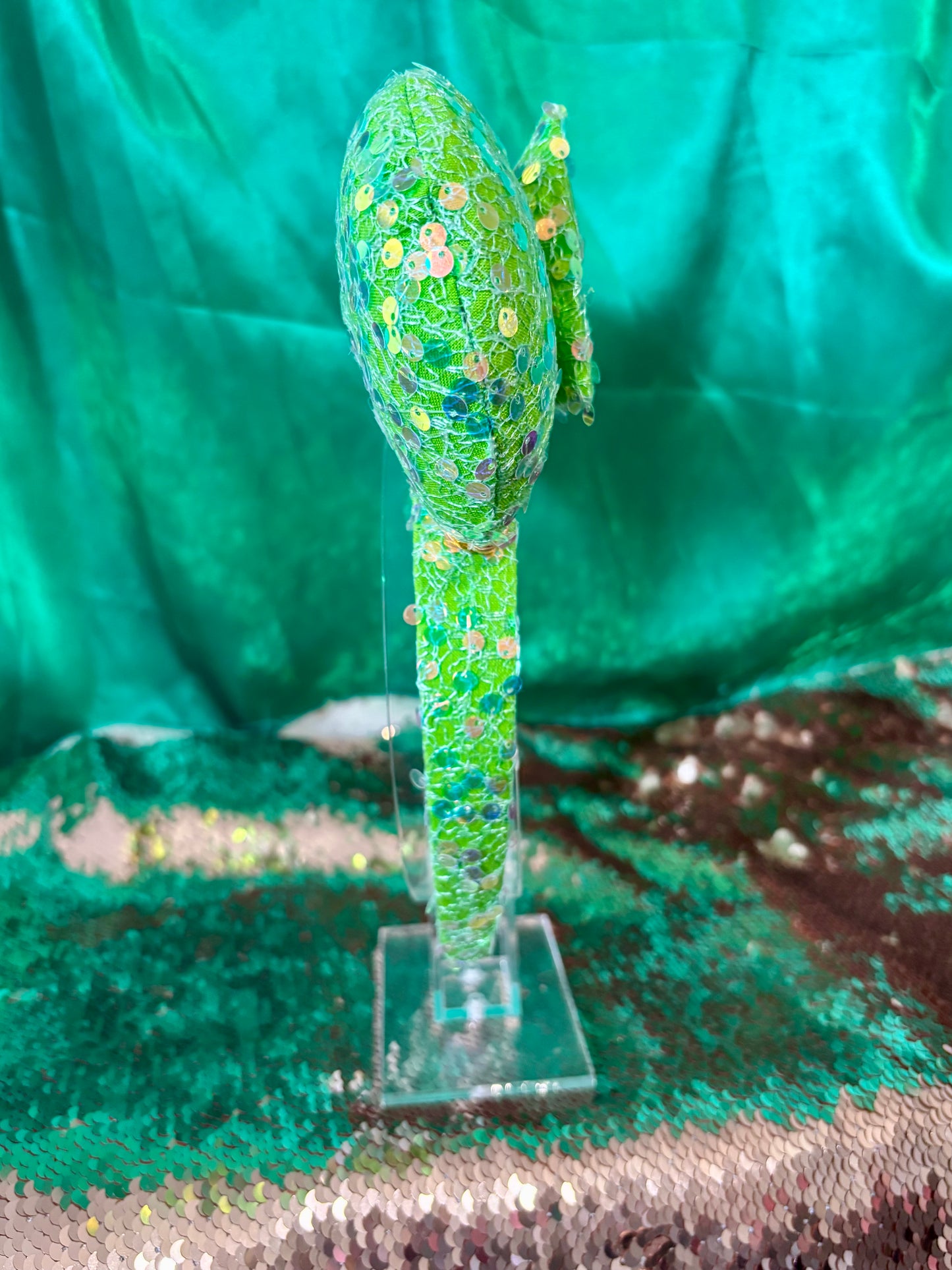 Bright lime Green sequin mouse ears on ears, headband and the bow with a gold trim. Shown on a pastel floral background