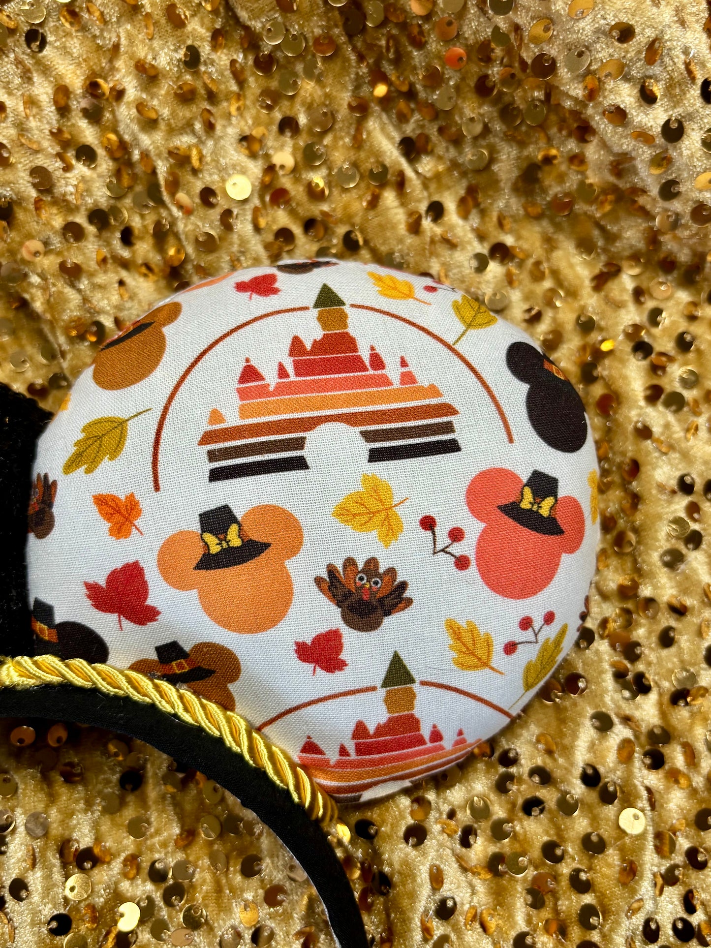Thanksgiving park themed mouse ears on a black headband with a black sequin bow.