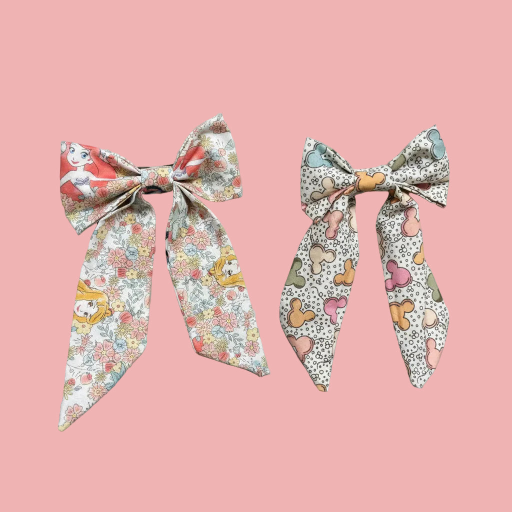 Handmade and ready to ship. Two French tailed hairbows come in this bundle in: Pretty Princess and Mouse Balloon fabric. French barrette backings are on the bow's backs.