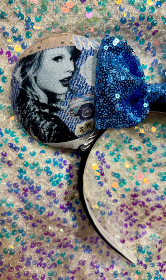 Decorative item with a woman's face and blue sequin heart on a glittery background