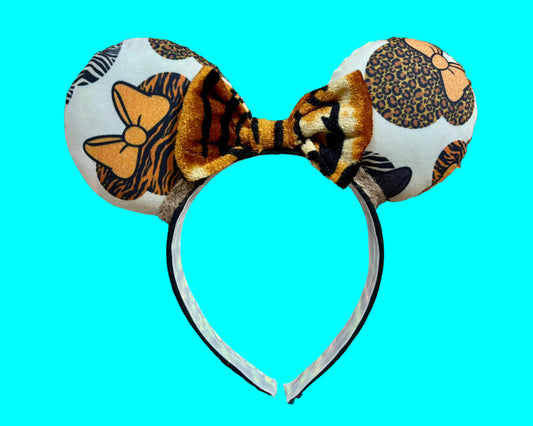 Safari mouse prints with bows are on the Mouse Ear headband with a soft tiger striped bow. You can request any color sequin bow in your order by leaving a note if you prefer one of those instead. Handmade and ready to ship with fabric on both the front and the back of mouse ears. The set has a jute twisted trim along the inner ears. Ears are on a black poly cotton universal sized headband.