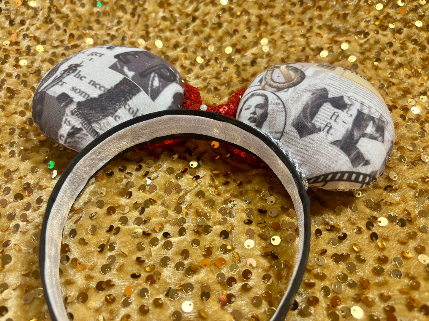 Mouse ears with newspaper print design on a glittery gold background
