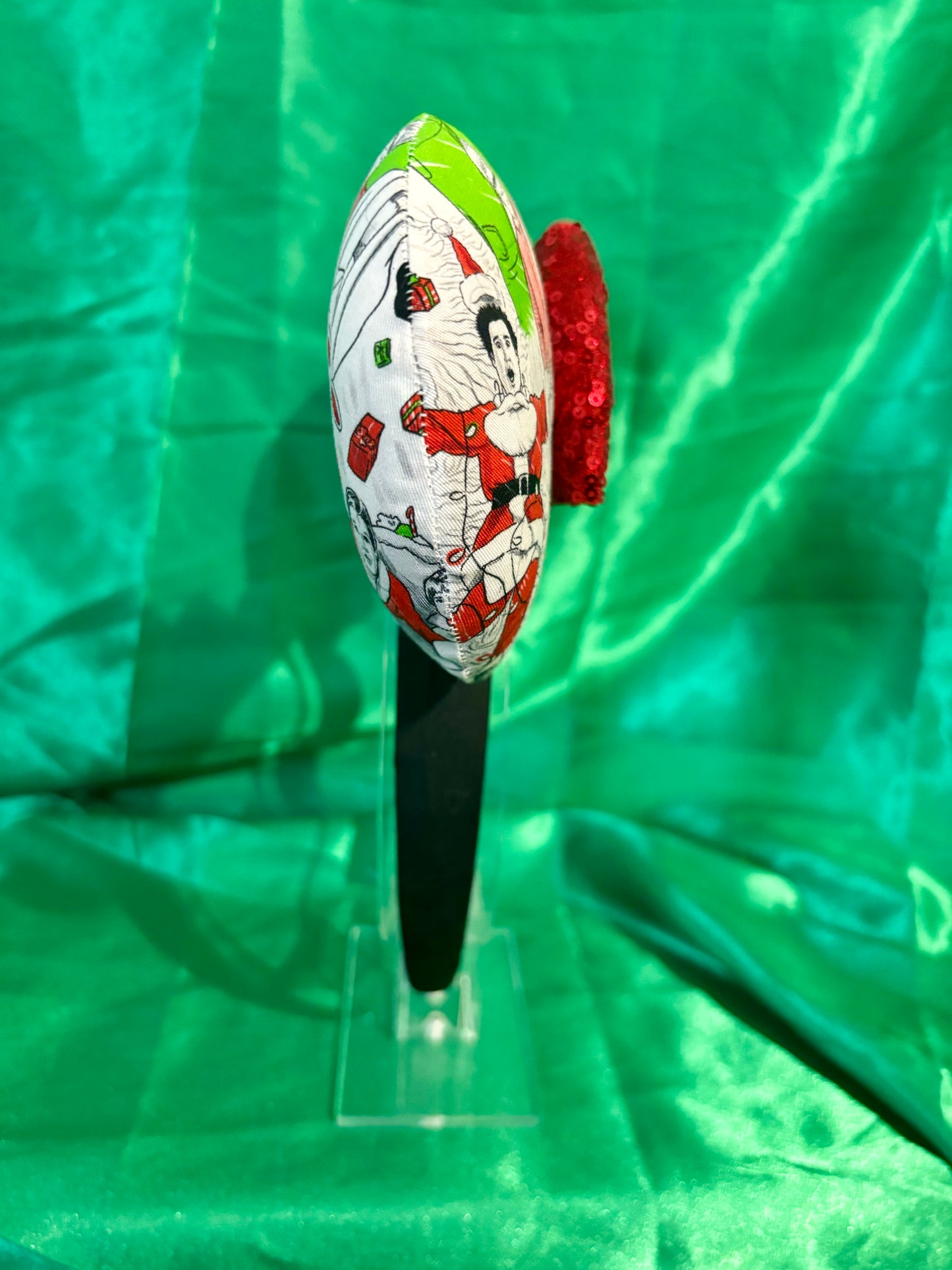 Classic Christmas films inspired fabric on front, back and the headband as well. These are handmade and ready to ship mouse ears with a red sequin bow. Shown on a green satin background.