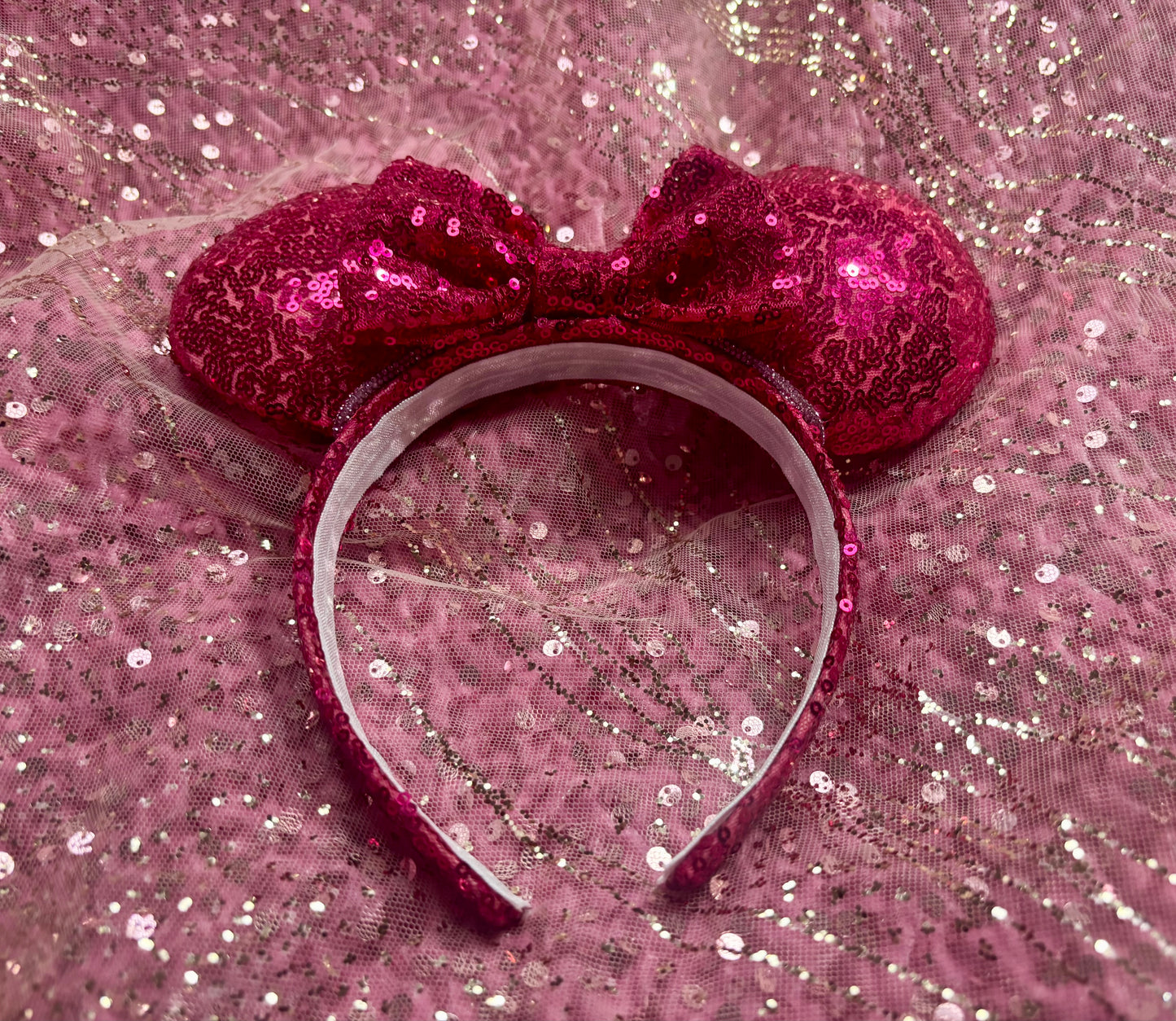 Handmade and ready to ship, Hot Pink Custom Ears. Fabric is on ears front and back with pink rhinestone trim along the inner ears and a matching hot pink sequin bow. The Headband is universal sized and has the same hot pink sequin fabric.