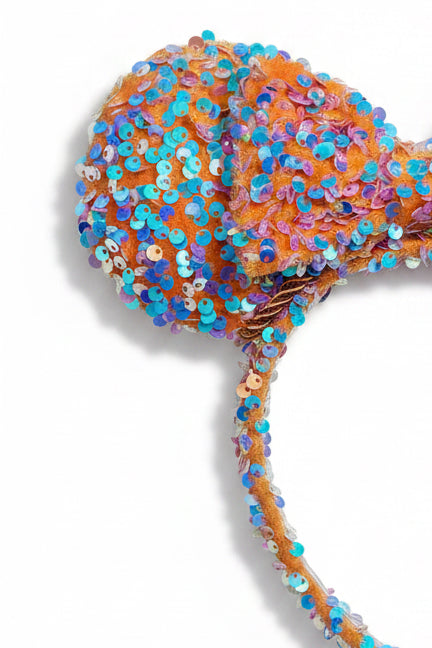 Colorful sequin headband with a bow on a white background