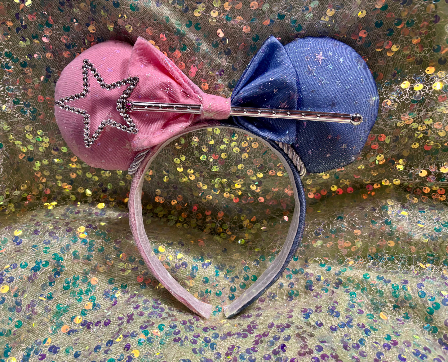 Handmade and ready to ship Sleeping Beauty Inspired Custom Ears. Sparkling Iridescent fabric is on both side of ears and the headband as well. Half blue and half is pink. The headband is universal sized and fits most. The set has a matching pink bow, silver trim and a magic want in the bow middle.