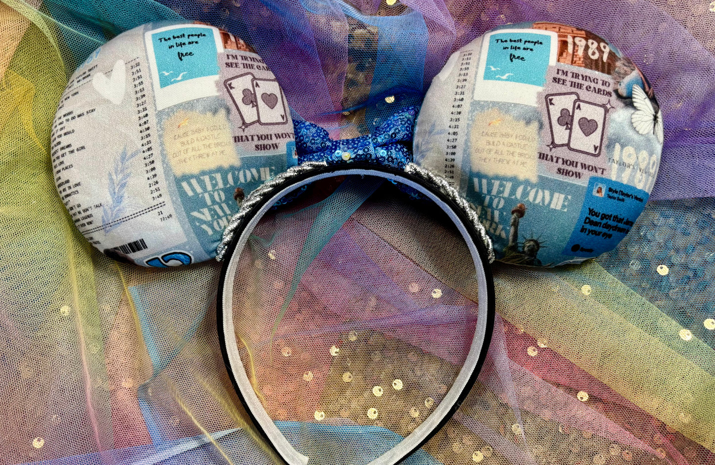 Mouse ears with a blue bow and newspaper print on a colorful background
