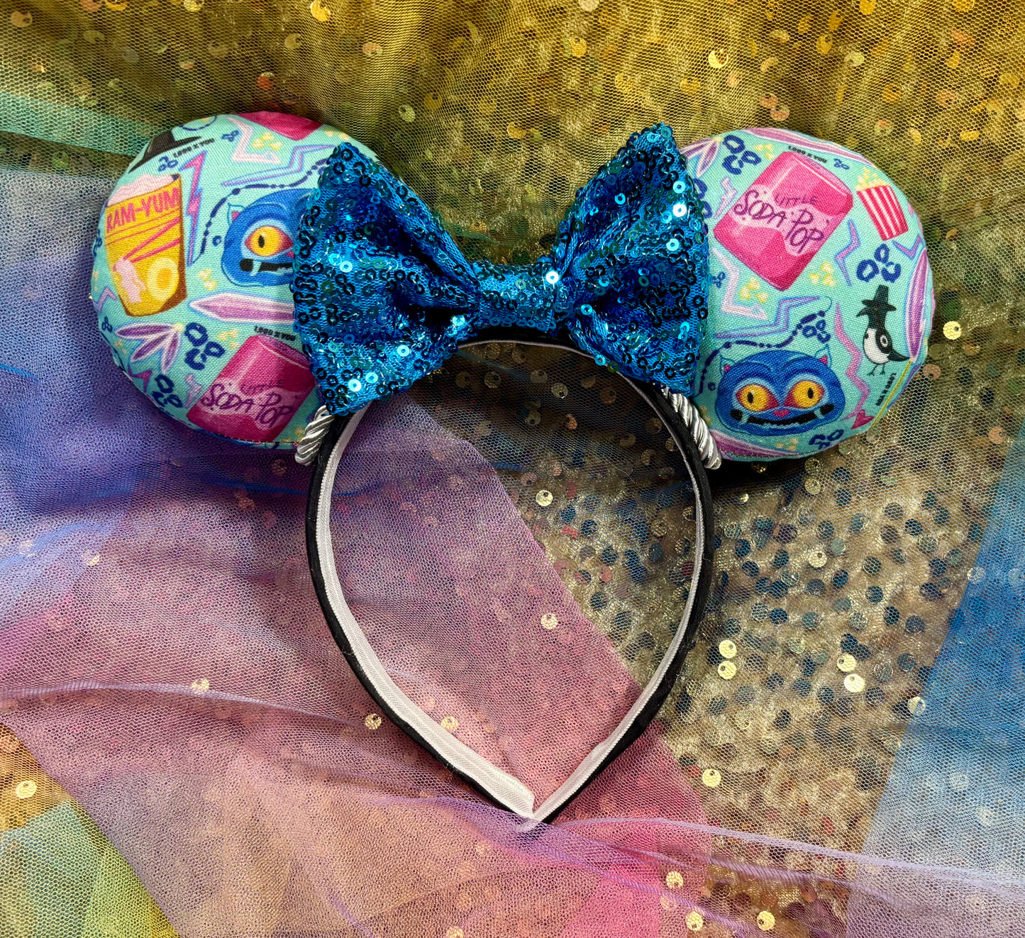 Colorful mouse ears with a blue bow on a glittery background
