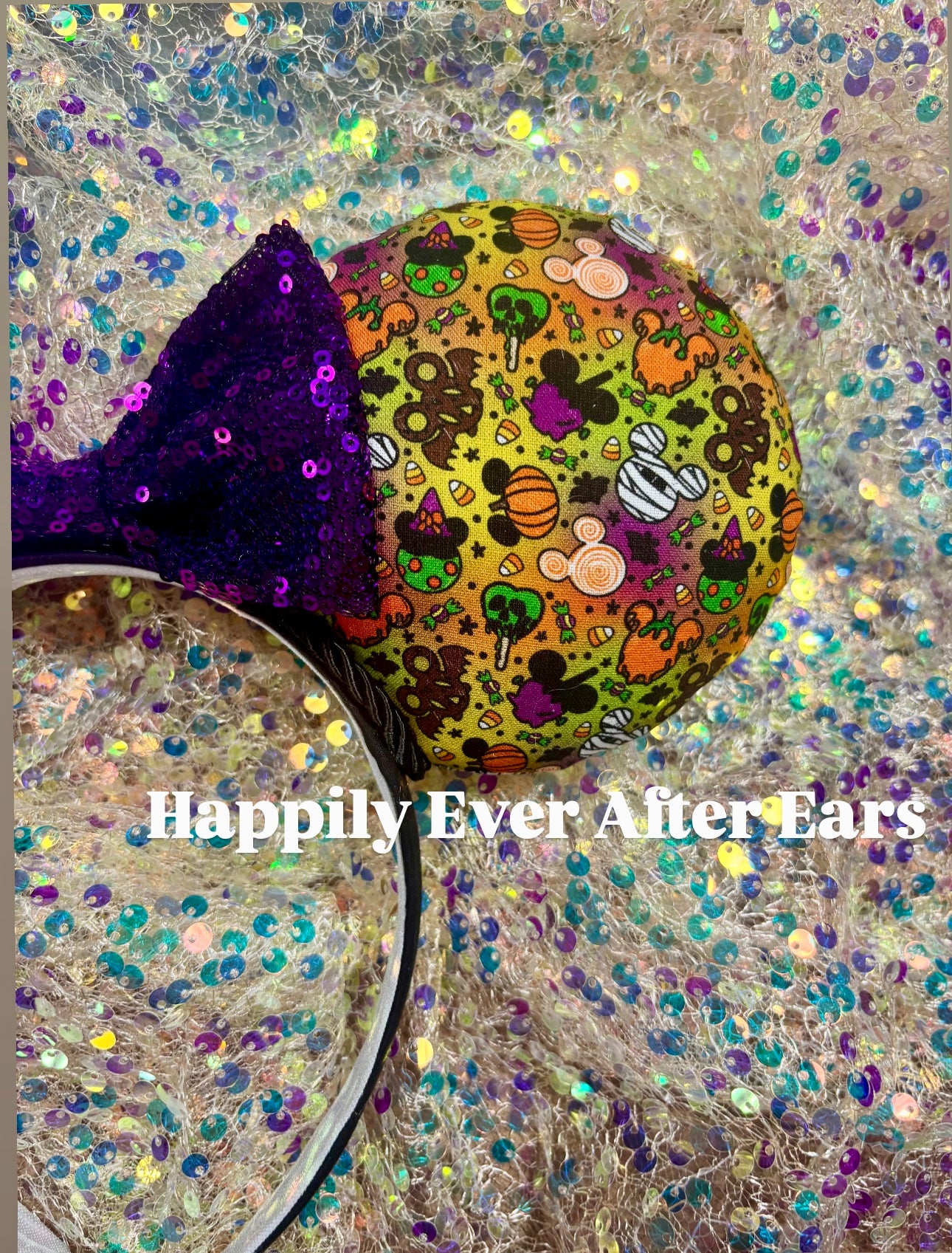 Colorful character ears with a purple bow on a glittery background, labeled 'Happily Ever After Ears'.