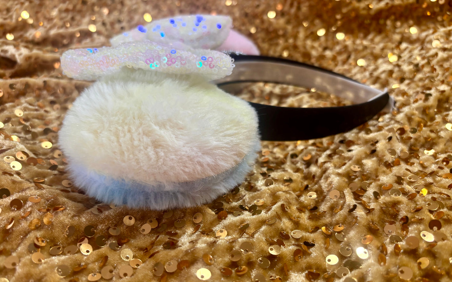 Mouse ears with a rose gold pleather bow and decorative elements on a textured satin background