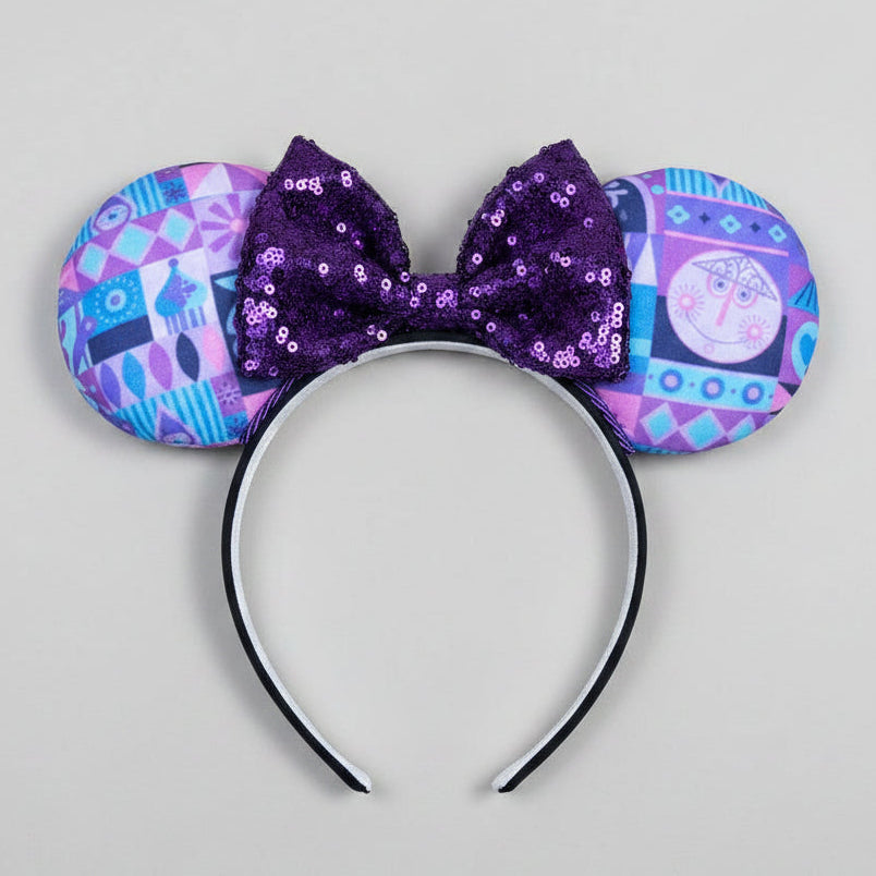 Decorative headband with purple bow and patterned ears on a white background