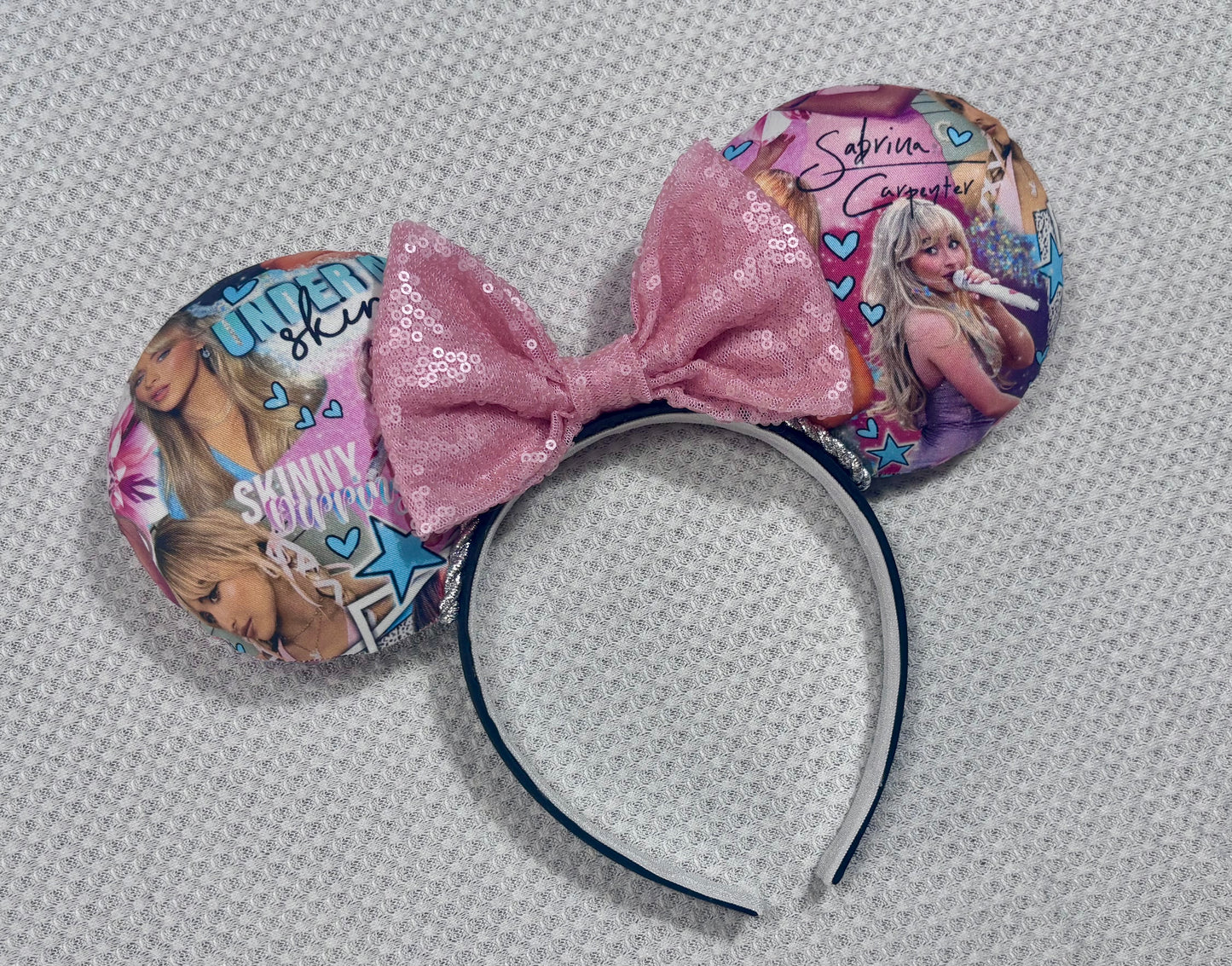 Handmade and ready to ship SC mouse ears with images of singer on the front and back of mouse ears with silver twisted trim and a light pink sequin bow on a black poly cotton headband.