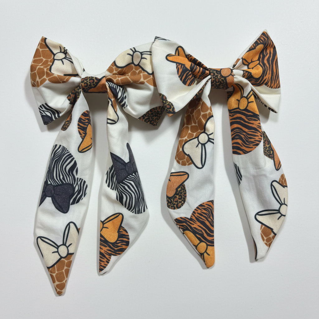 Two fabric bows with animal print patterns on a white background