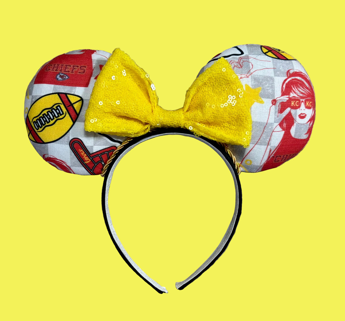 An ear headband featuring a bright yellow sequined bow. The set has TS and Chiefs images on it. Set on a universal sized headband.