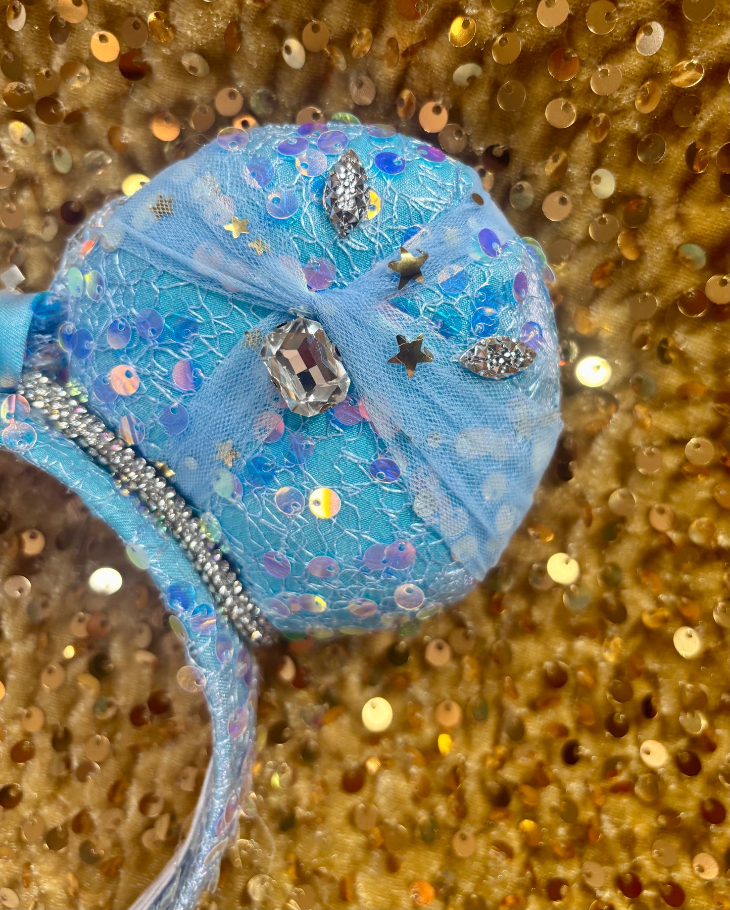 Handmade and ready to ship blue sequin mouse ears headband inspired by Cinderella with tulle and silver gemstones with a crown charm middle and rhinestone trim along inner ears.