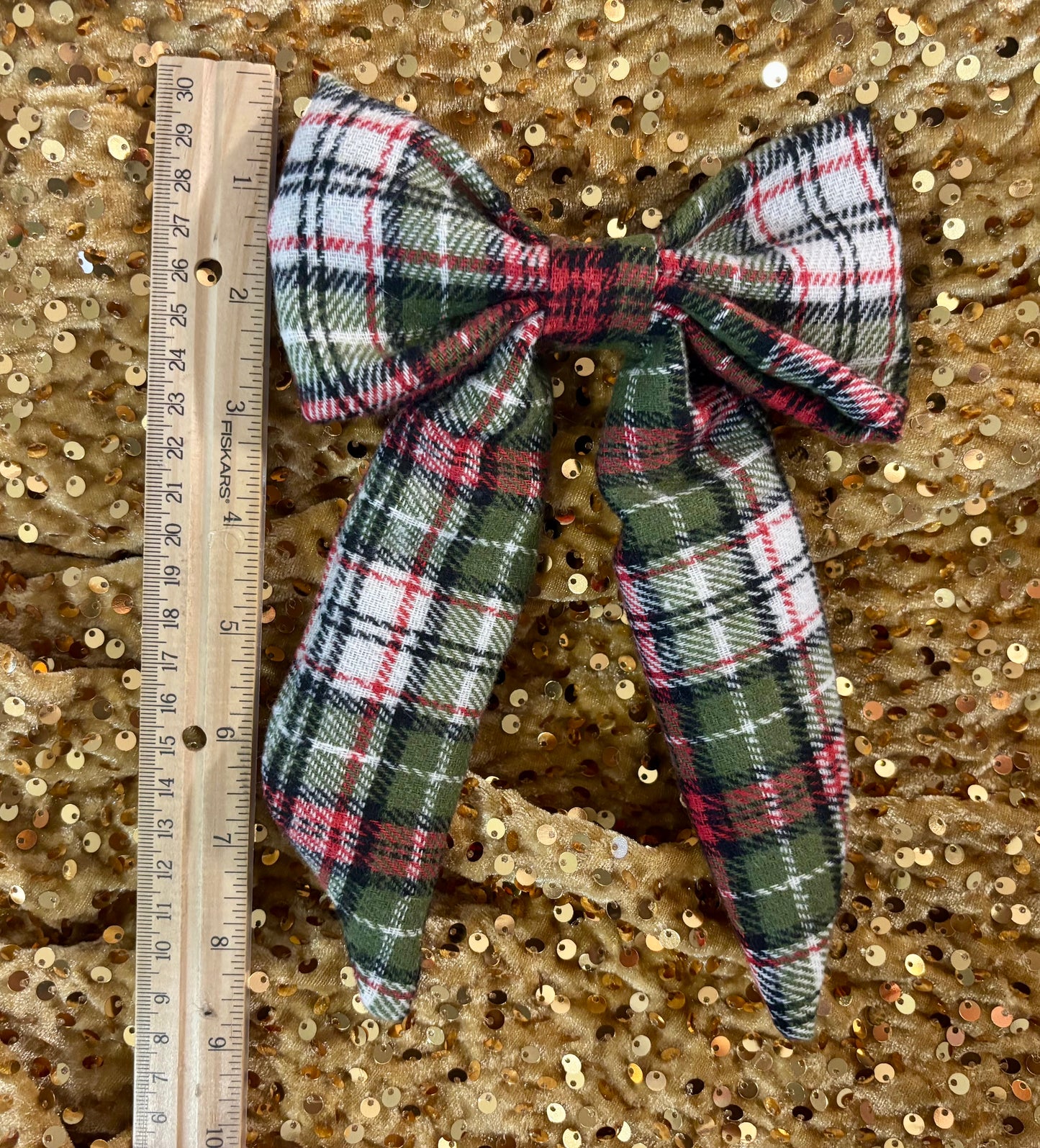 Plaid bow with a ruler on a gold sequin background