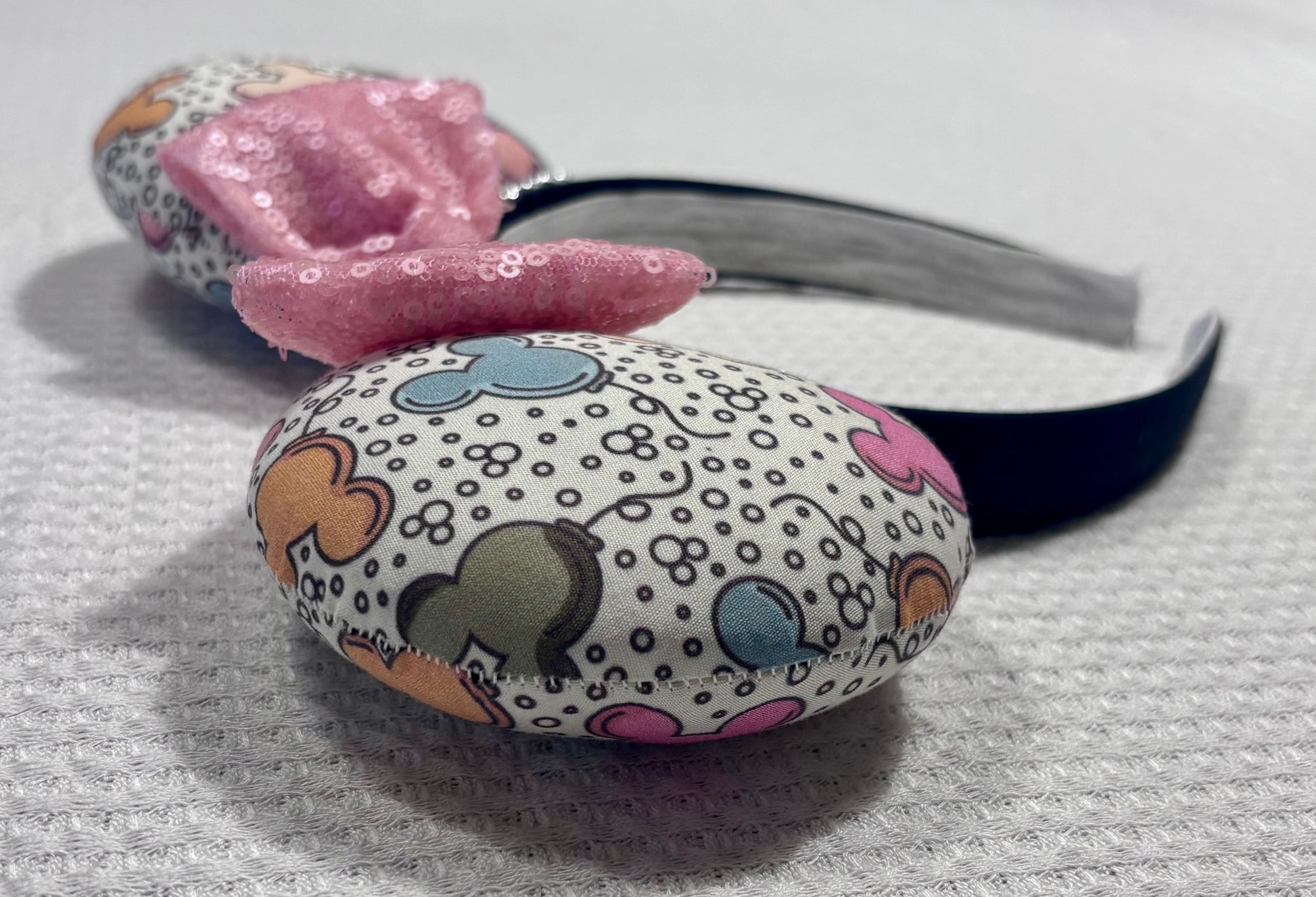 Close up of other side view of mouse ears along with the stitching. Handmade and ready to ship Mouse ears mouse balloons with a light pink sequin bow. Perfect for Main Street. Shown on a white background.