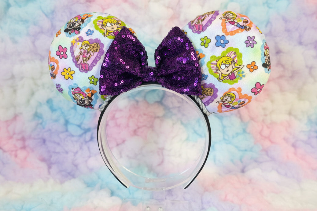 Colorful minnie mouse ears inspired by the Lizzie cartoonwith a purple sequin bow. Shown on a pastel cloud background