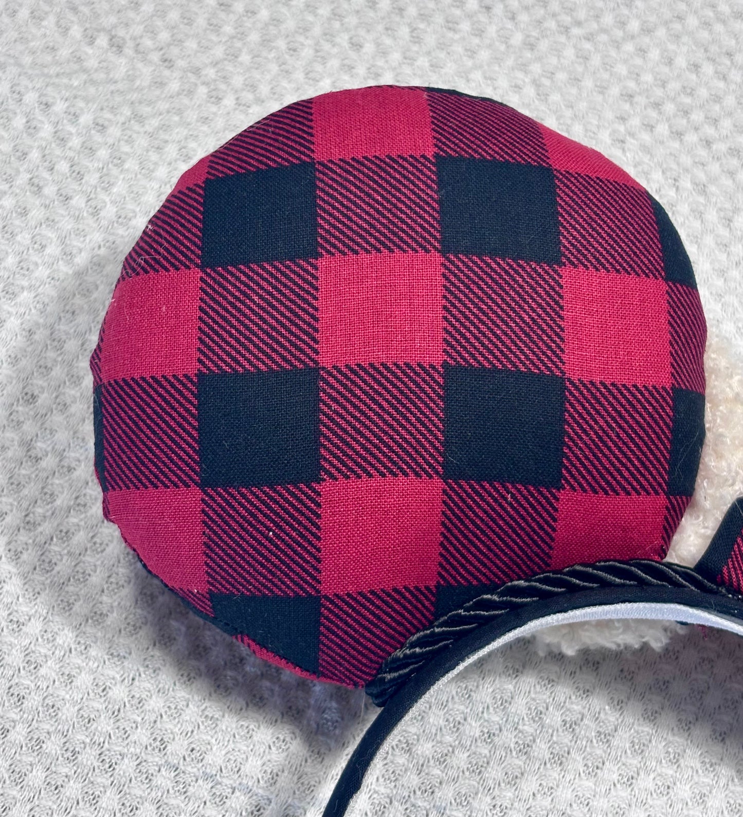 Handmade and ready to ship Buffalo Plaid mouse ears on both the front and back. On a black headband that is universal sized. The set has an off-white soft bow with buffalo plaid middle. Item is shown on a white background.