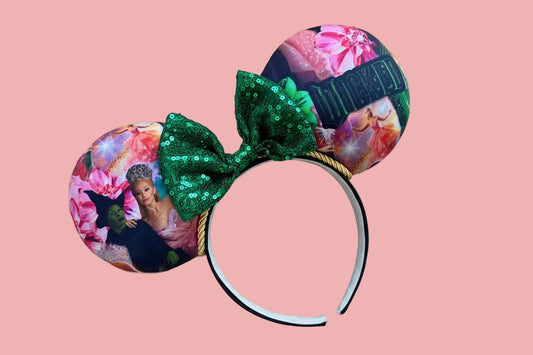 Handmade and ready to ship Wicked Inspired Defying Gravity mouse Ears. The fabric is on the ears front and back with yellow twisted trim along the inner ears. Green sequin bow, but you can write me a note in your order if you prefer a different color. The set is on a black poly cotton universal sized headband. 