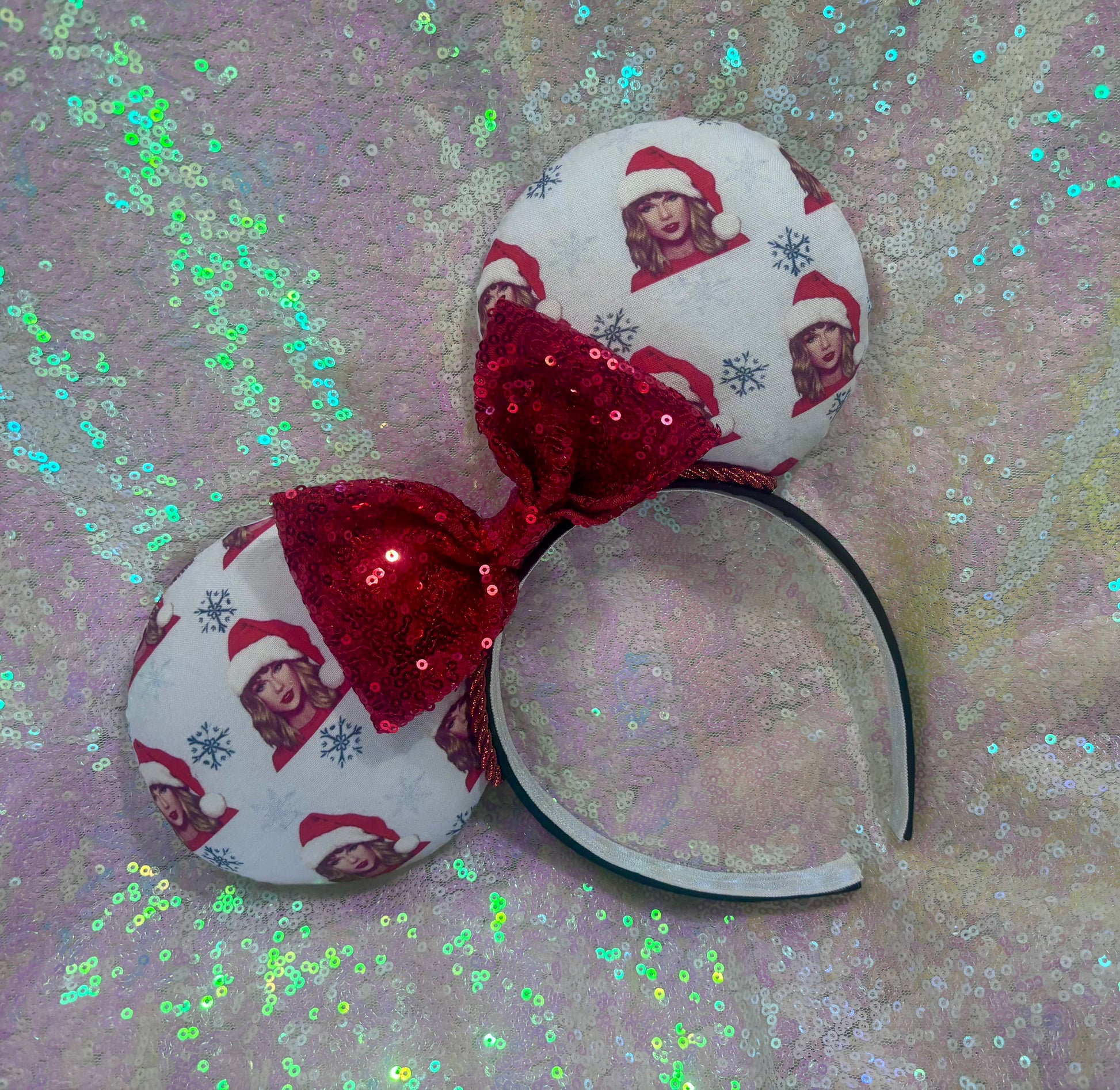 Christmas-themed headband with red bow and printed design on a glittery background