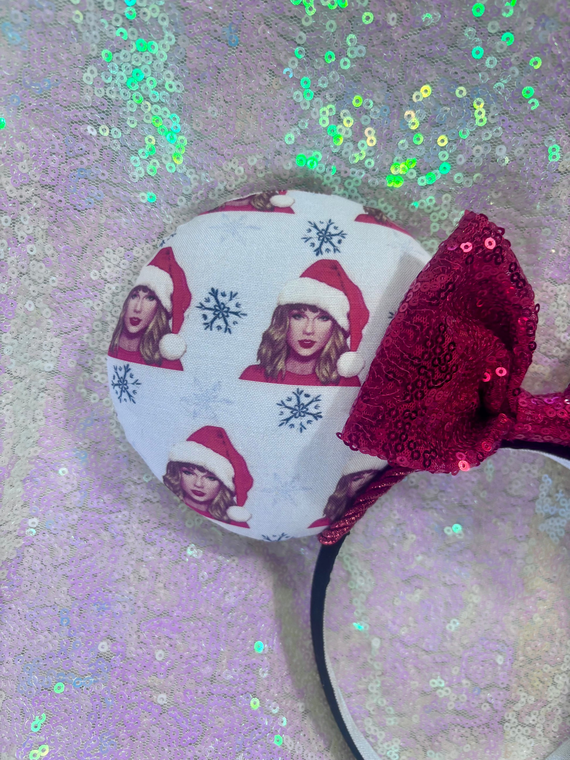 Decorative headband with red bow and festive design on a glittery background