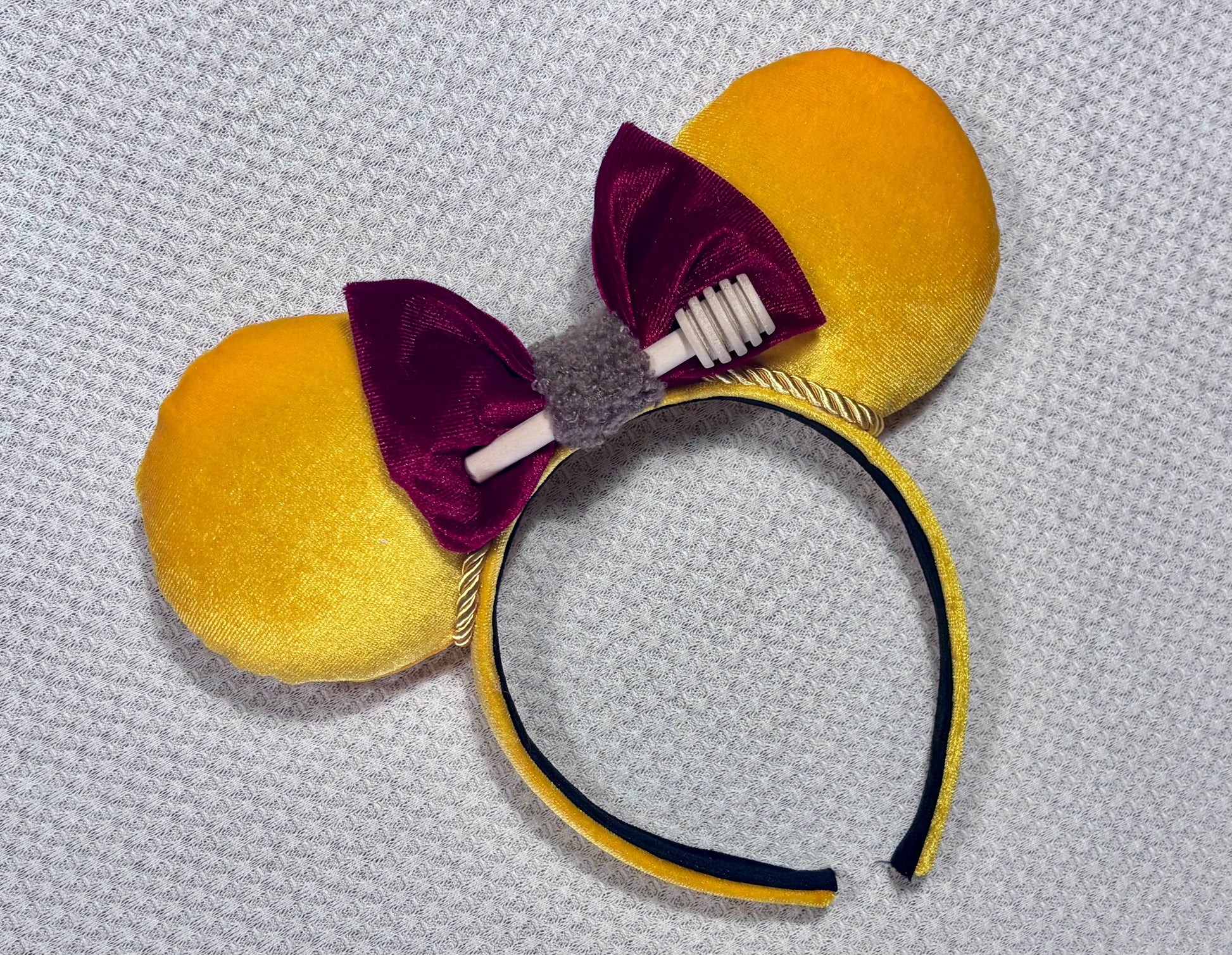 Yellow mouse ears with a red bow with a mini honeycomb and fluffy brown middle