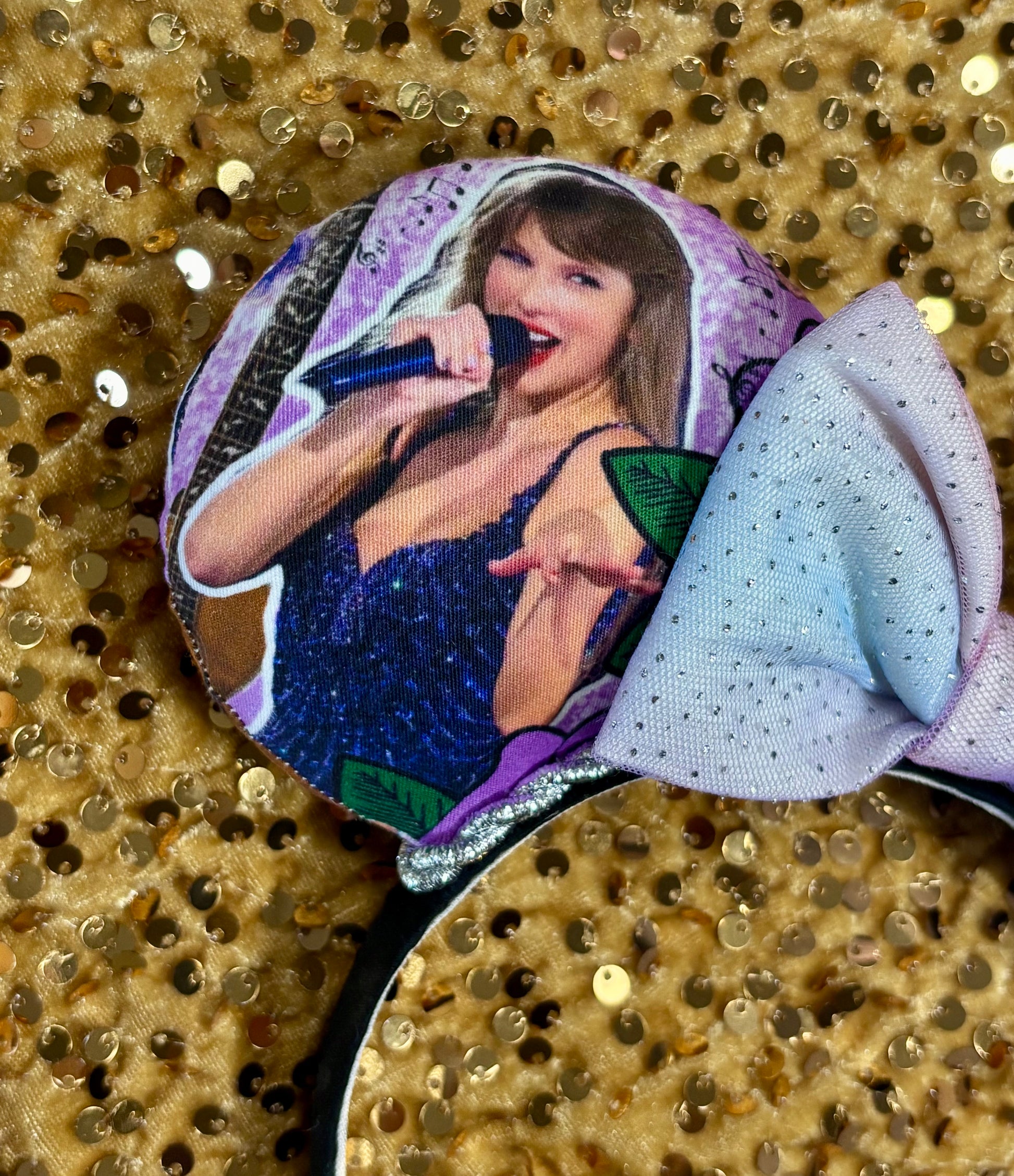 Close up of front mouse ear and Ts singing into a mic. Handmade and ready to ship TS Mouse ears with a new beautiful sewn tulle bow with sparkles on it. Of course, you can still request any bow in sequin if you prefer and I will attach it. Shown on a gold sequin background.