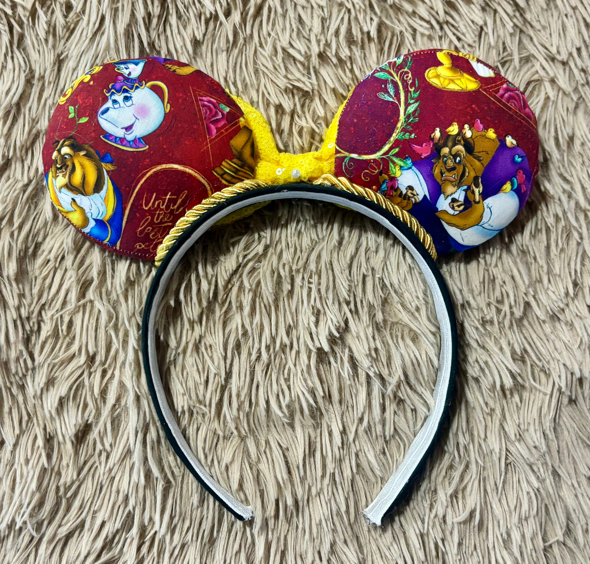 Handmade ear headband featuring a large yellow bow and multicolor print with Belle and the Beast.