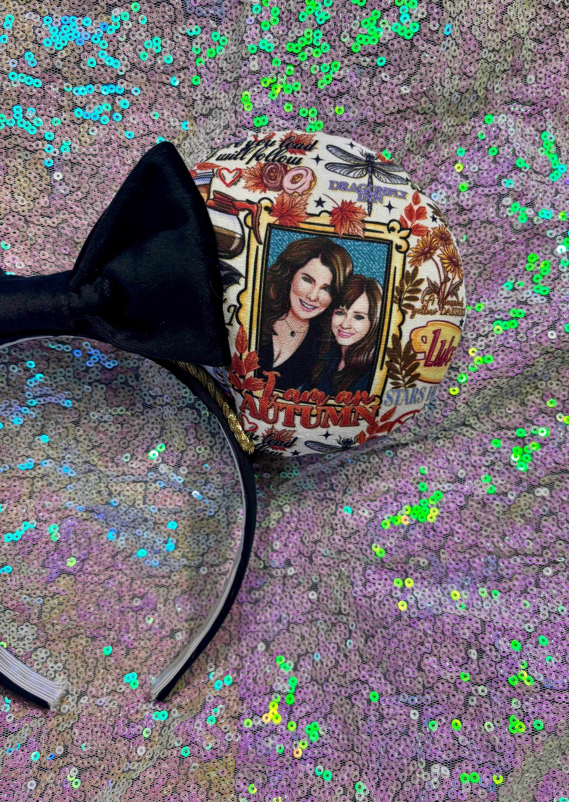 Close up view of front right side mouse ear showing cartoon Lorelai and Rory.