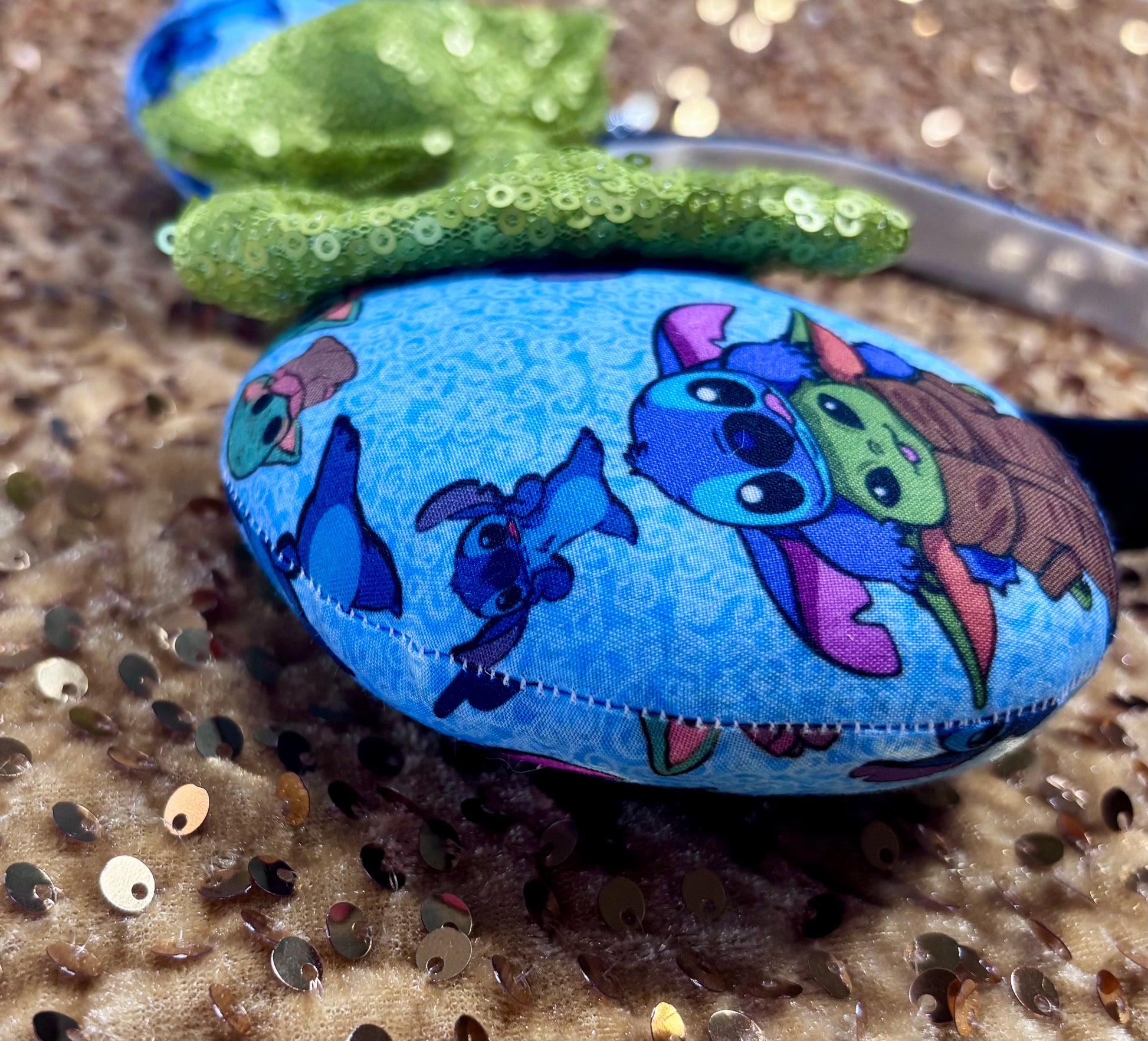 Handmade and ready to ship small friend aka Stitch and Baby Yoda Mouse ears with a lime green sequin bow. Of course, you can request any bow in sequin if you prefer and I will attach it. Shown on a white background. Close up of mouse ear and the stitching on mouse ears.