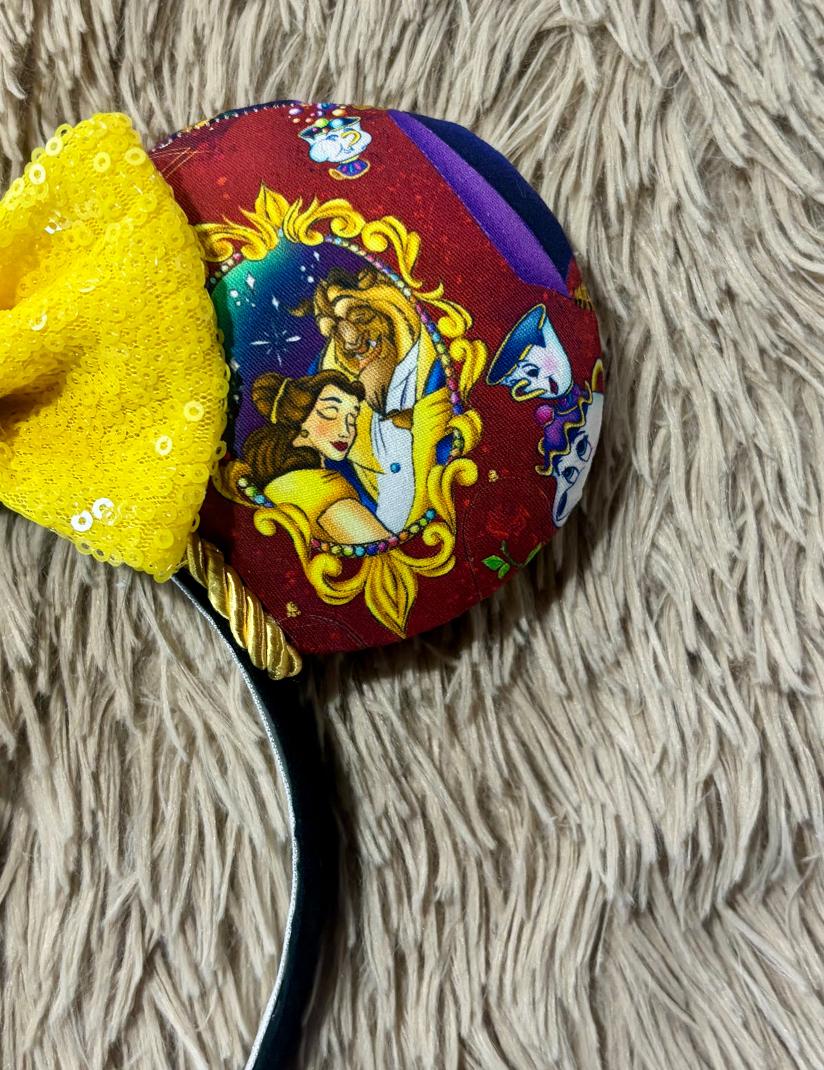 Handmade ear headband featuring a large yellow bow and multicolor print with Belle and the Beast.