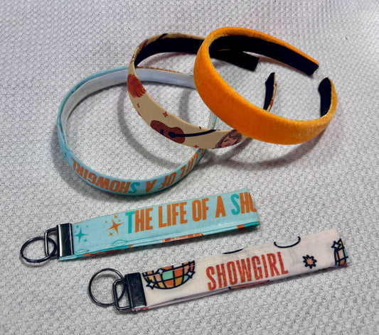 Set of three handmade and ready to ship colorful headbands and two keychains on a white background