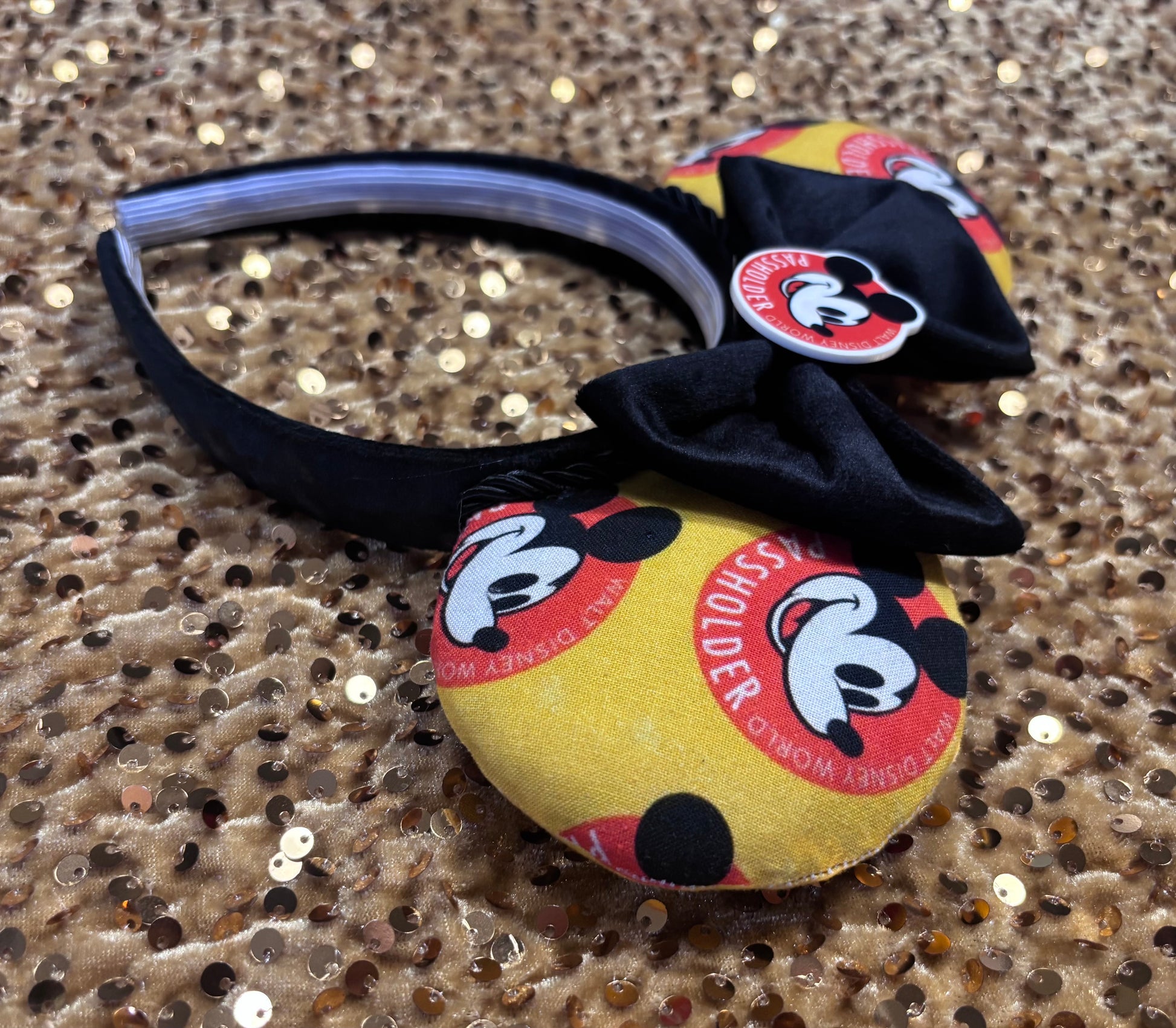 AP Mouse-themed headband with black bow on a glittery background