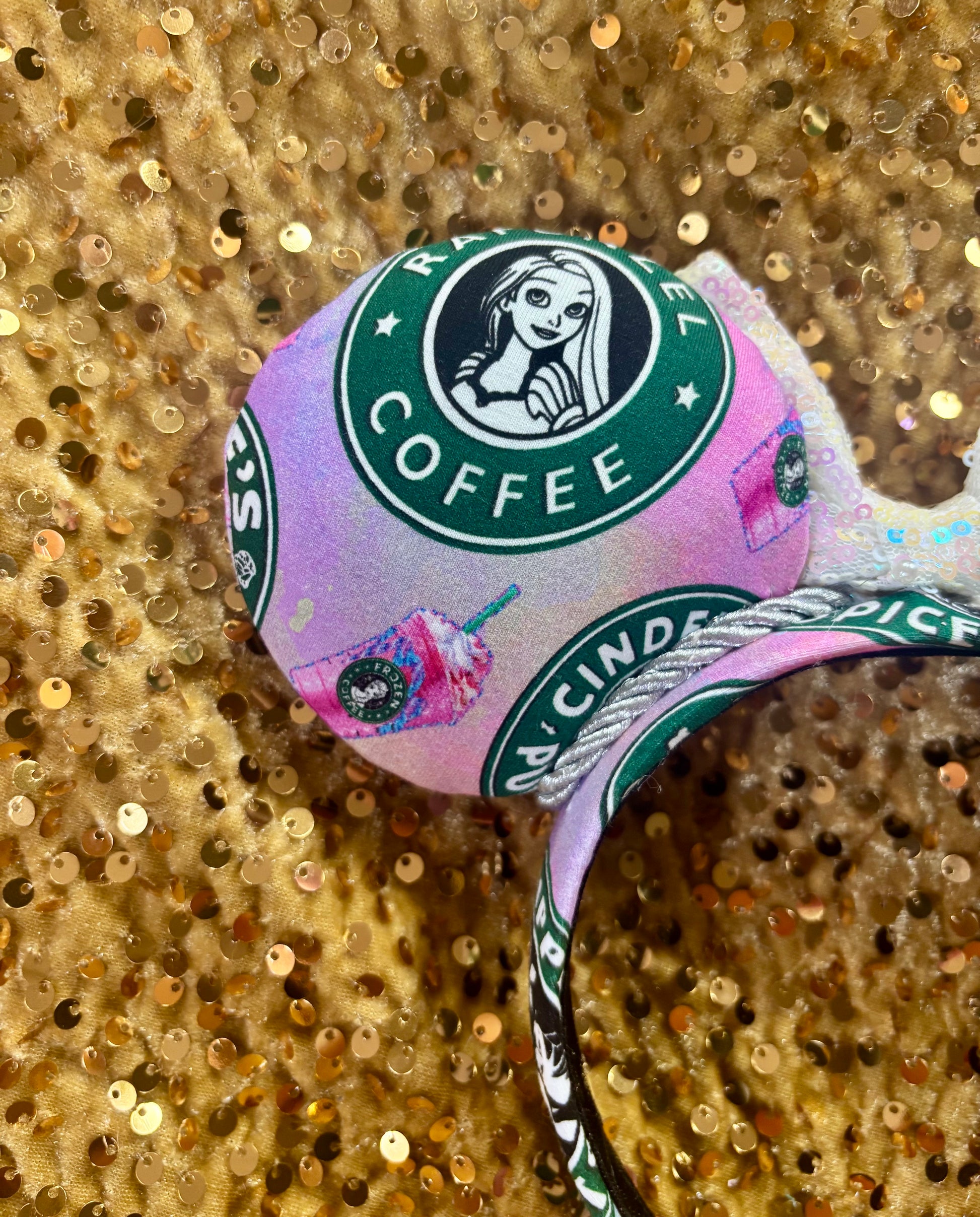 Handmade and ready to ship custom ears with popular coffee themed with princesses on fabric. White iridescent bow and silver twisted trim on a universal sized headband with matching design as the mouse ears. Back view of other ear showing Rapunzel.