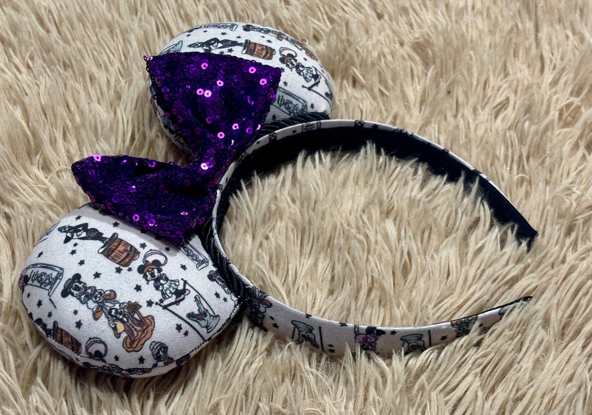 A set of ears with a fab 5 stretching room fabric on the ears front and back along with the headband as well. Black twisted trim along the inner ears with a purple sequin bow. 