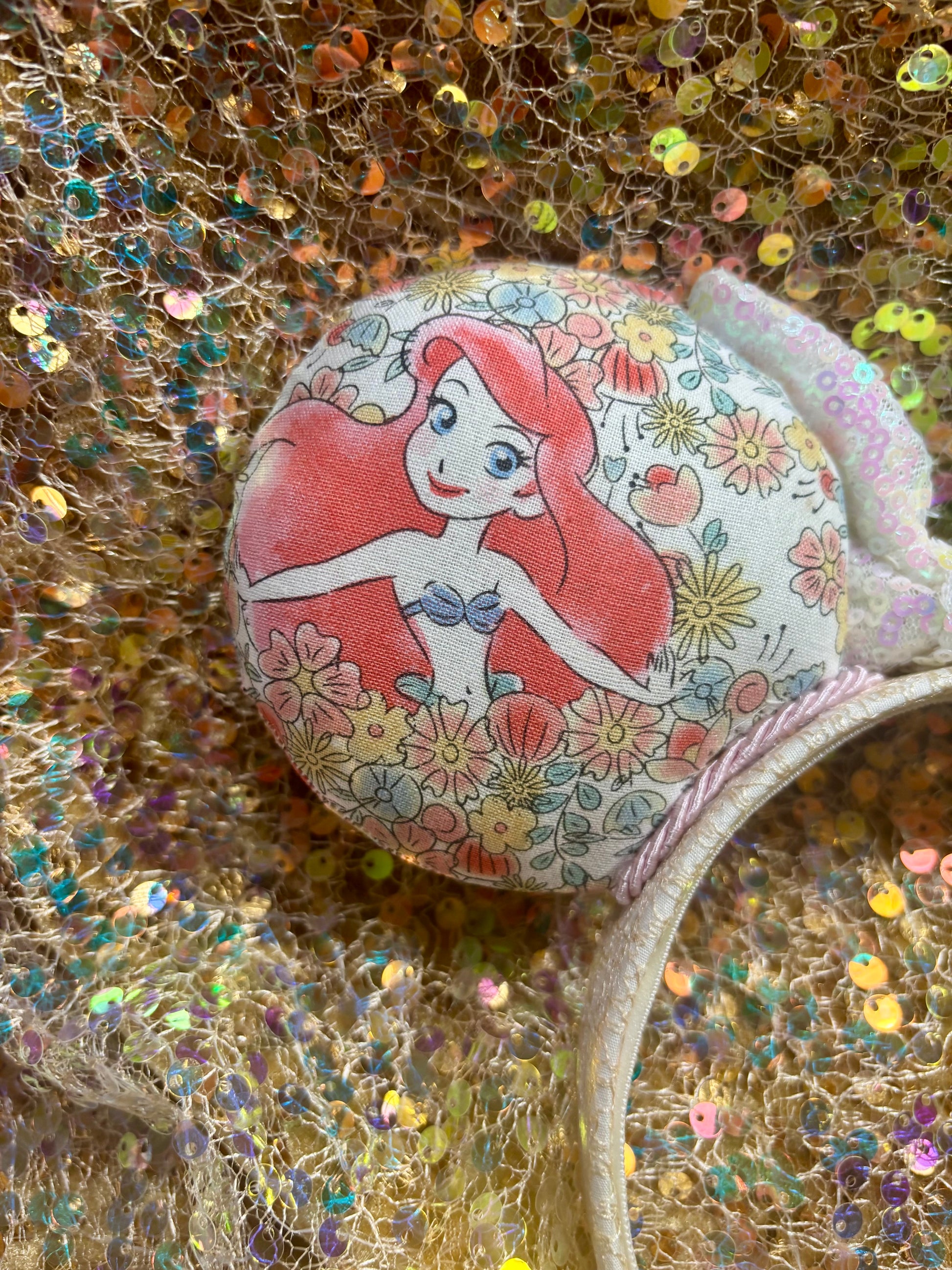Mermaid-themed decorative item on a glittery background