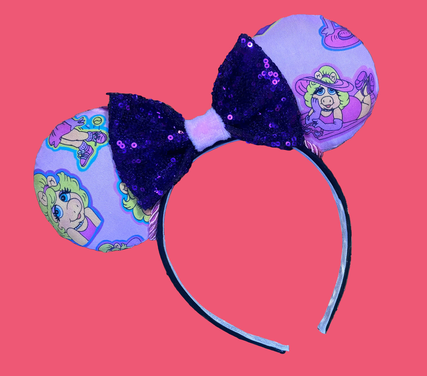 Handmade and ready to ship Piggy mouse ears. Miss Piggy fabric is on the front and the back. On a universal sized black poly fabric headband. With a purple sequin with pink soft middle on the bow. 
