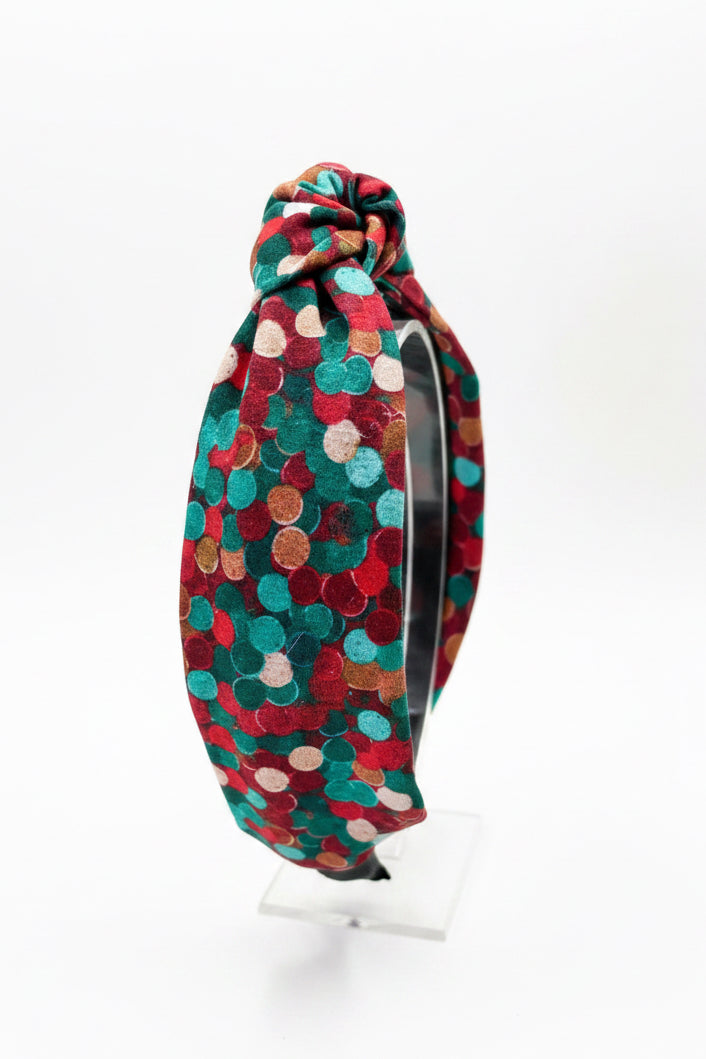 Side view of the Christmas Colors headband on a clear stand.