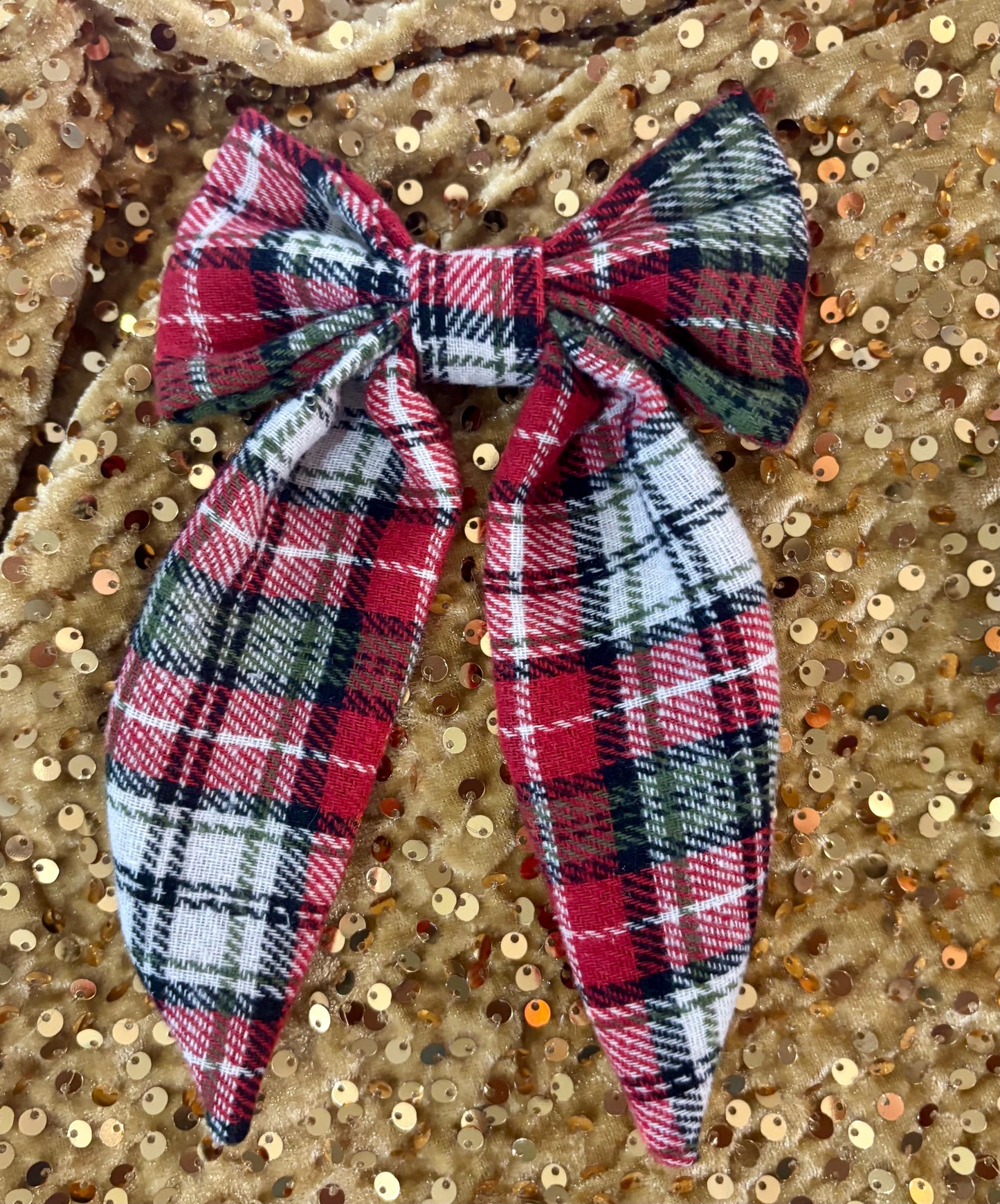 Plaid bow hair accessory on a gold sequin background