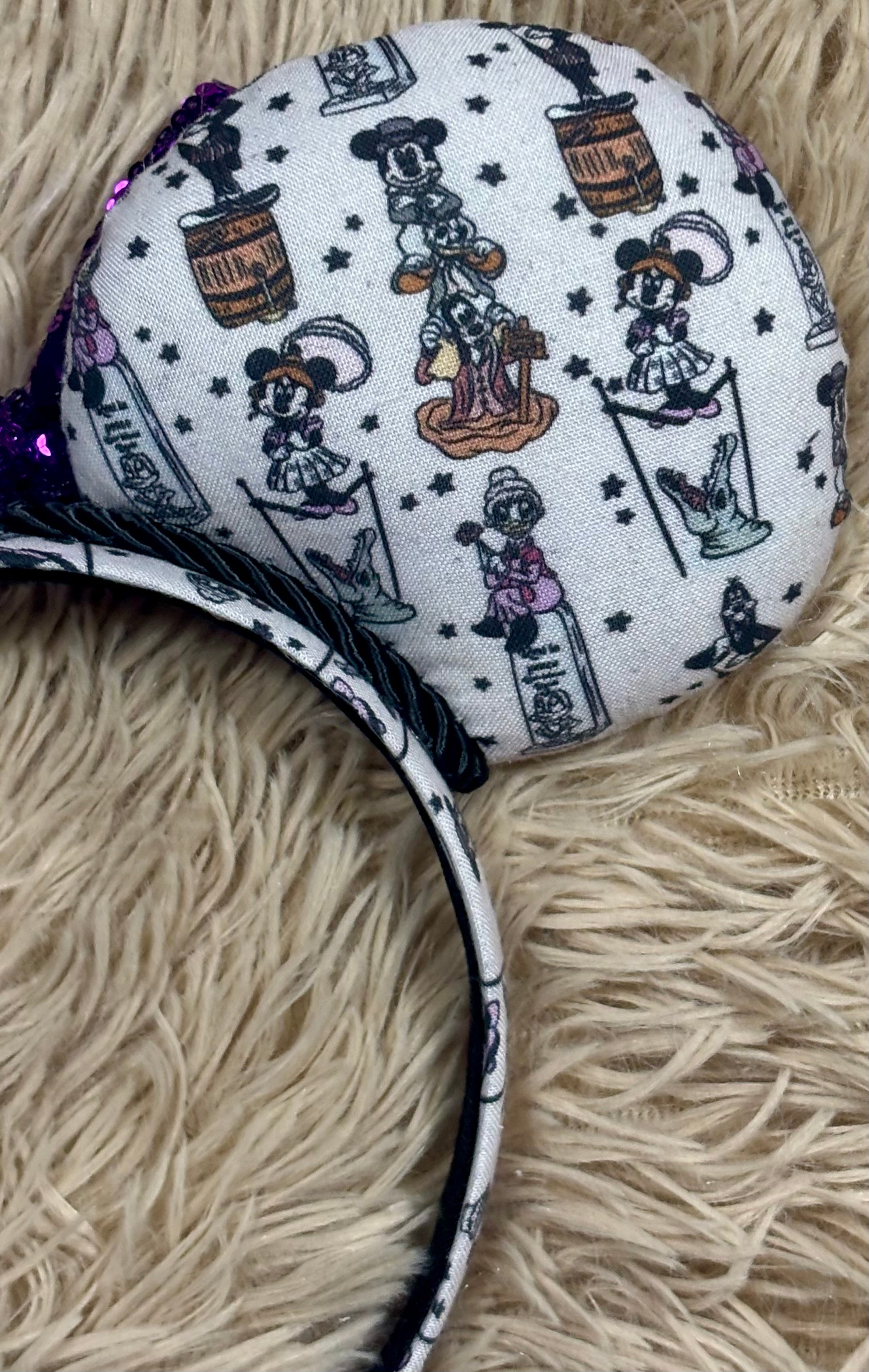 A set of ears with a fab 5 stretching room fabric on the ears front and back along with the headband as well. Black twisted trim along the inner ears with a purple sequin bow. 