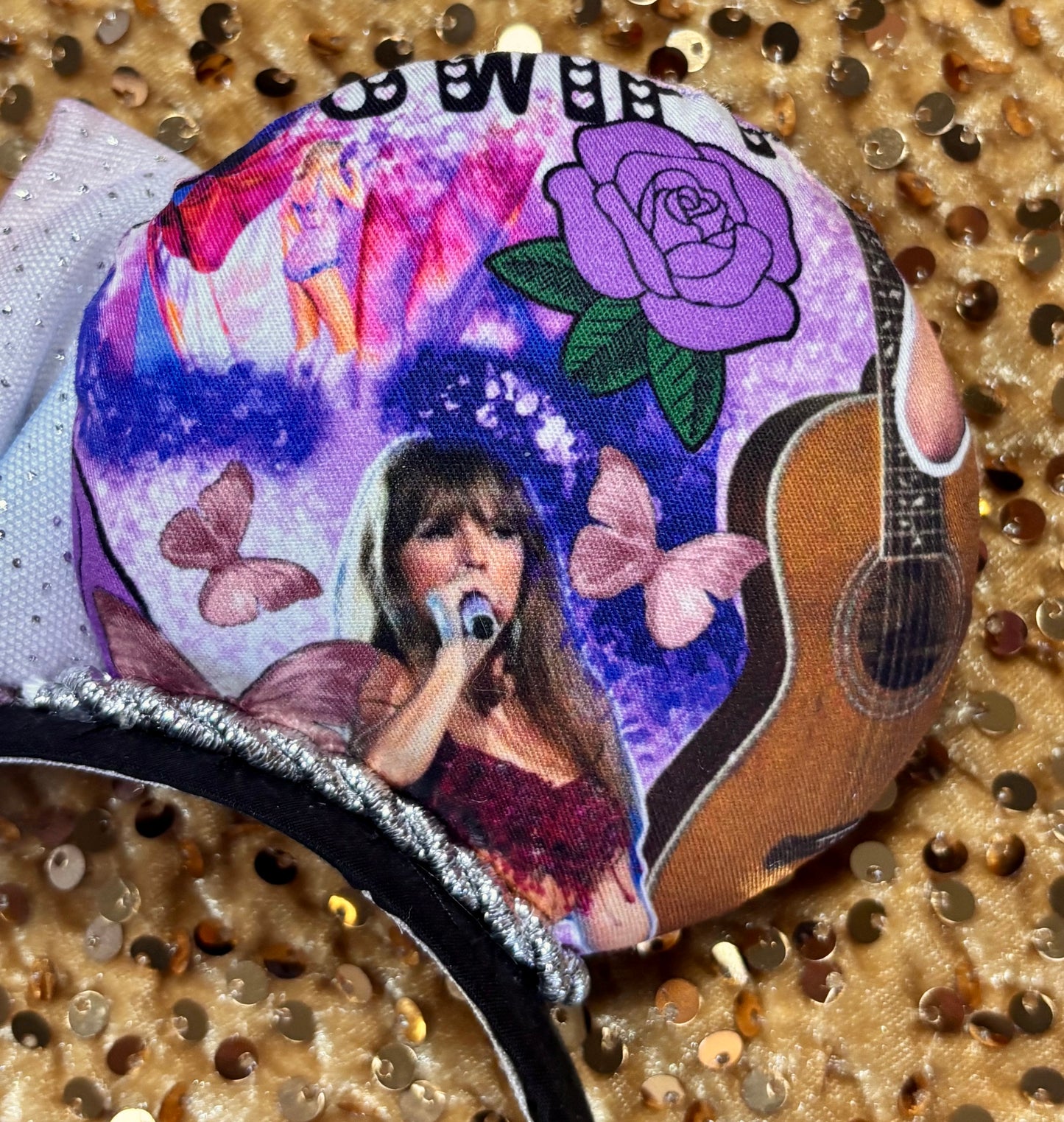 Right back side close up of mouse ear. Handmade and ready to ship TS Mouse ears with a new beautiful sewn tulle bow with sparkles on it. Of course, you can still request any bow in sequin if you prefer and I will attach it. Shown on a gold sequin background.