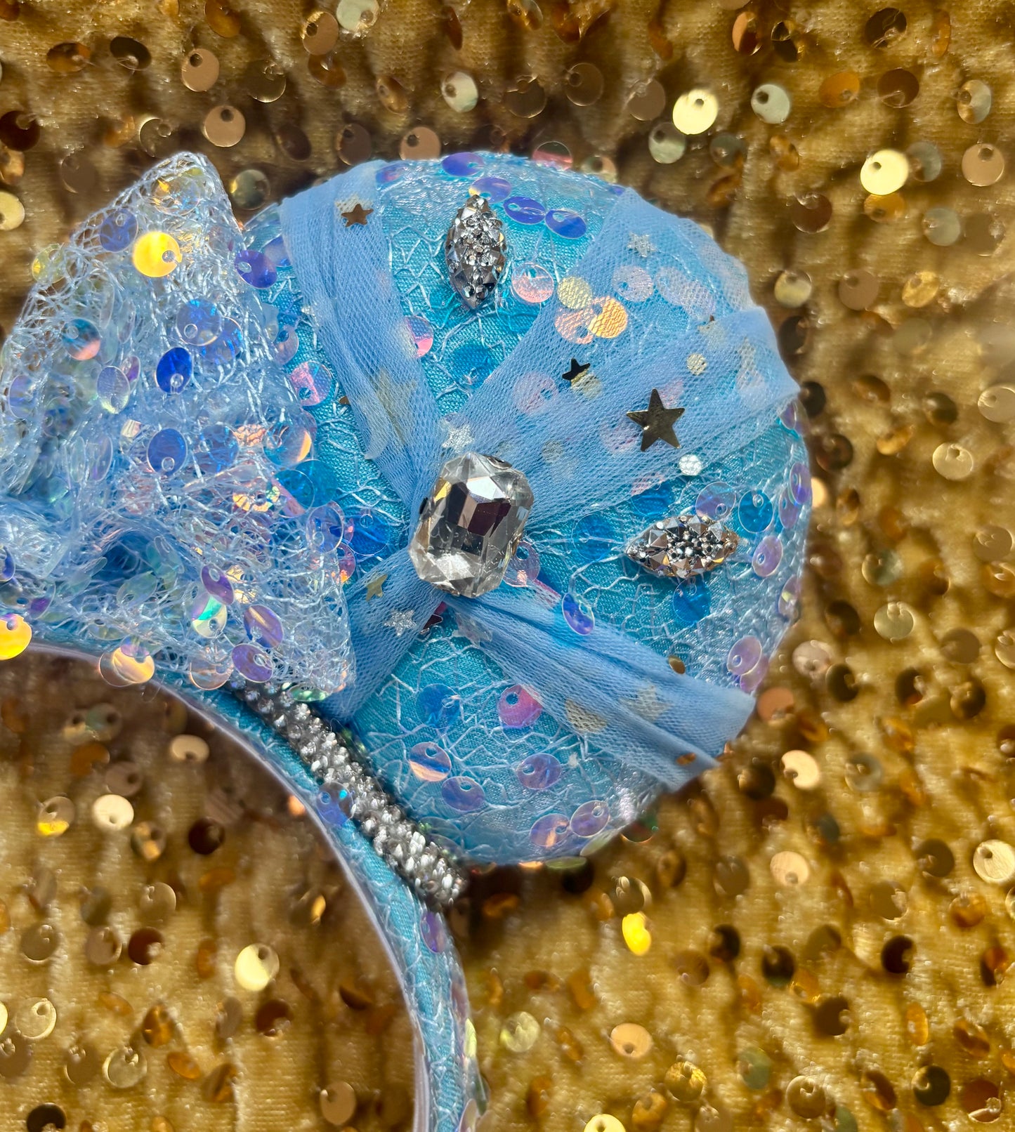 Handmade and ready to ship blue sequin mouse ears headband inspired by Cinderella with tulle and silver gemstones with a crown charm middle and rhinestone trim along inner ears.