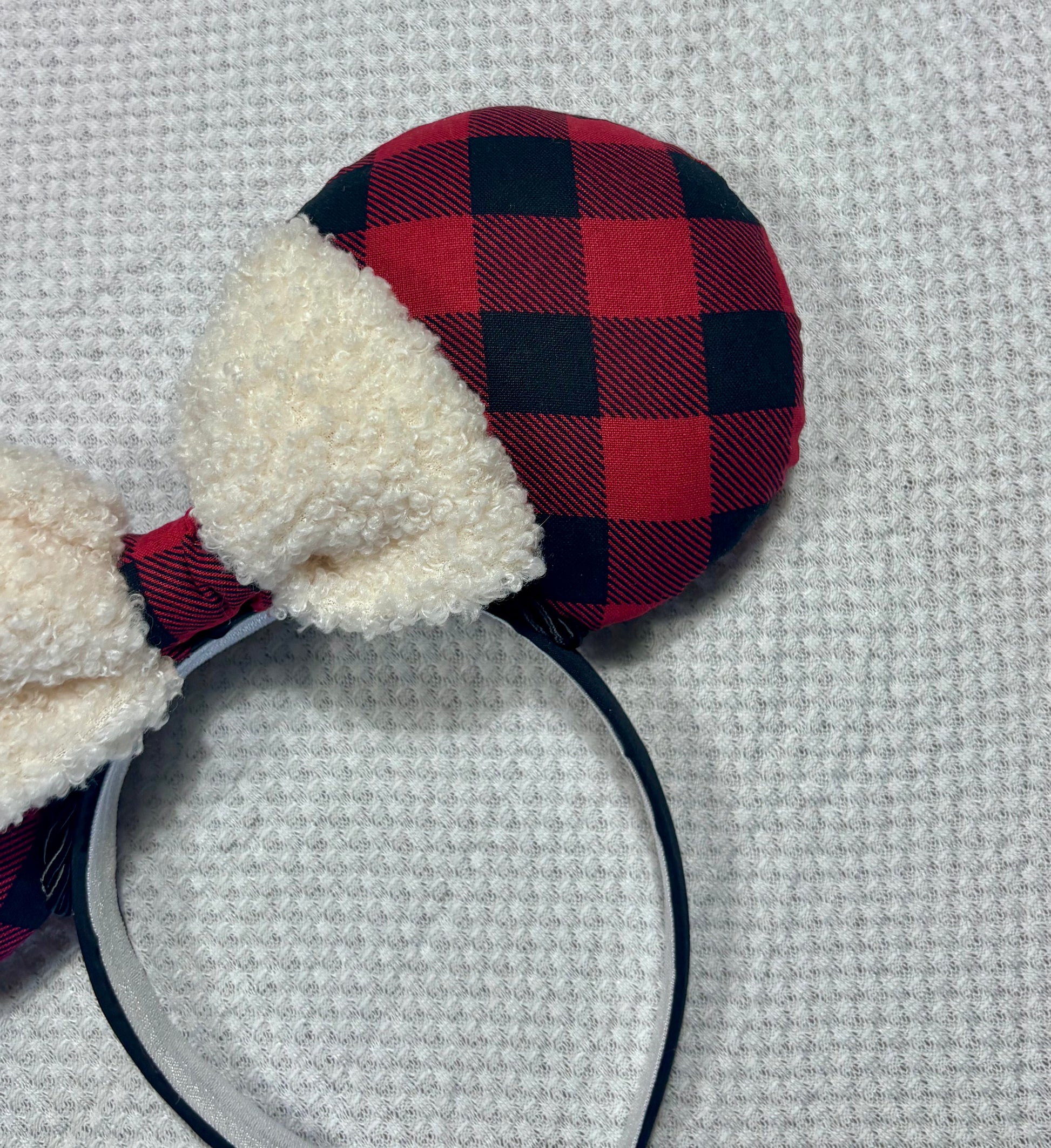 Handmade and ready to ship Buffalo Plaid mouse ears on both the front and back. On a black headband that is universal sized. The set has an off-white soft bow with buffalo plaid middle. Item is shown on a white background.
